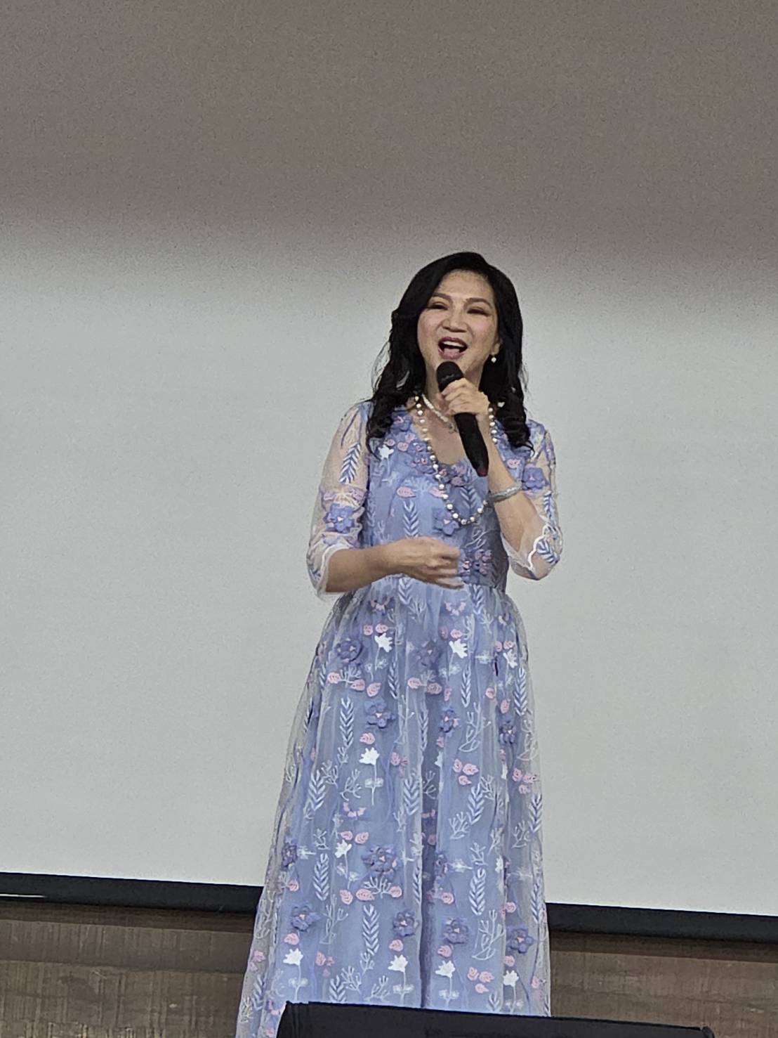 小百合(周月綺)獻唱〈小城故事〉,並為張任芝蘭師母獻花。(台北市電影委員會提供)