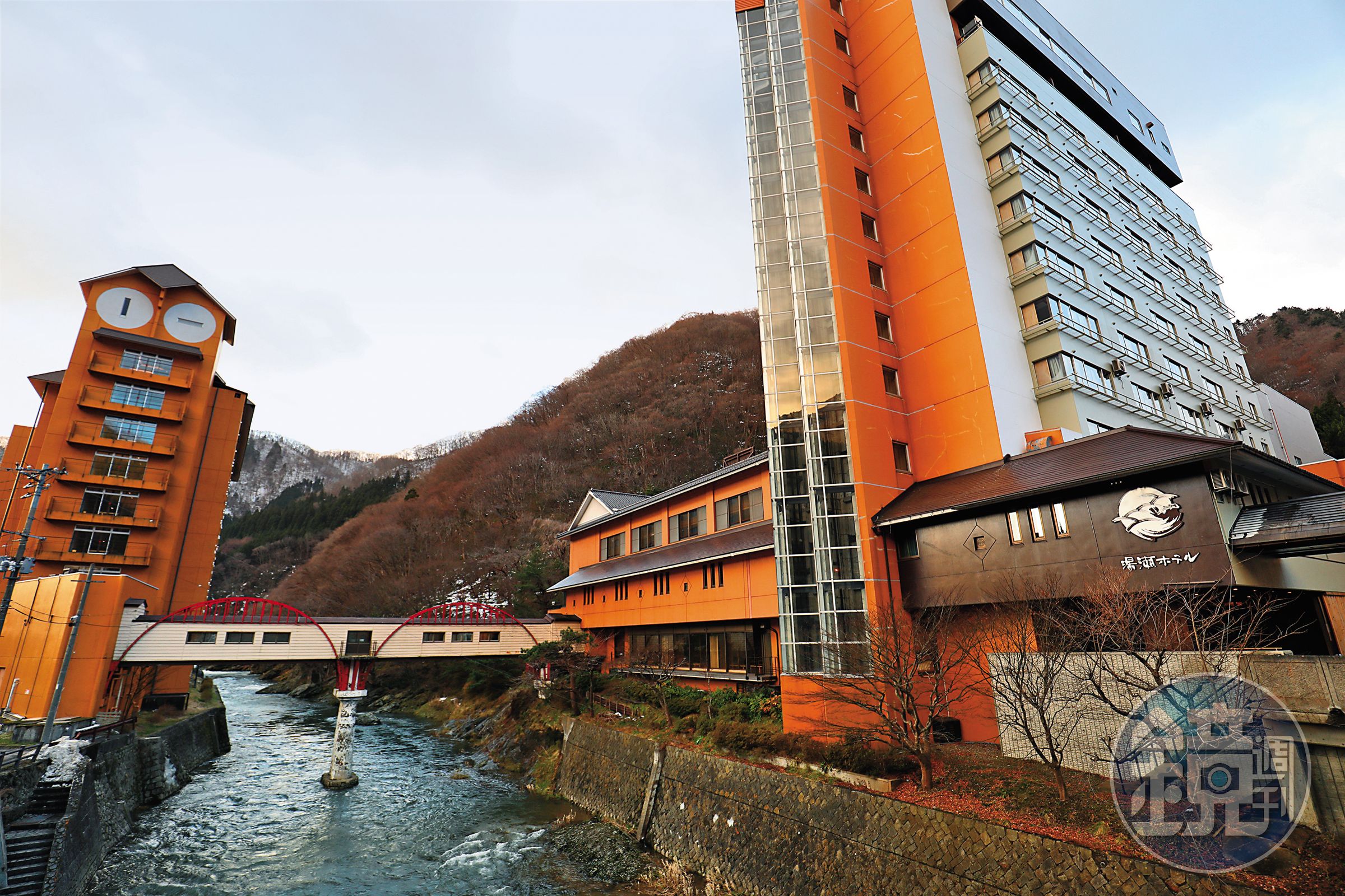 「湯瀨溫泉Yuze Hotel」以一座跨越米代川的紅橋連接新館與舊館。