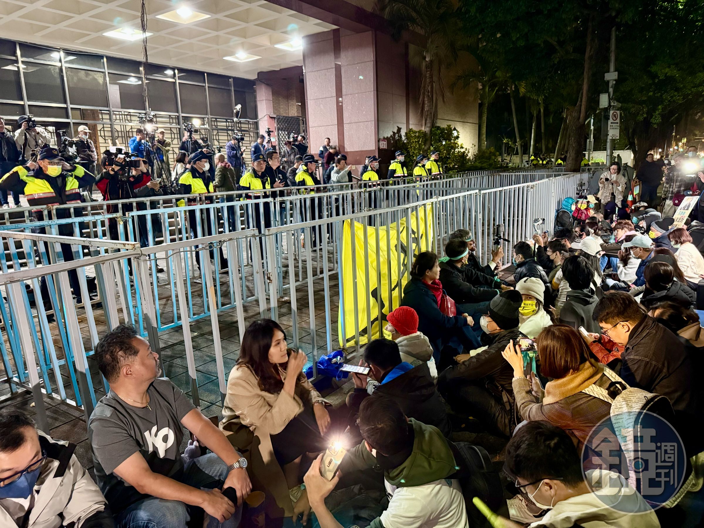 民眾黨組織部宣布6點發動「北檢前集結」，如今陸續有支持者到場，手勾手席地而坐。