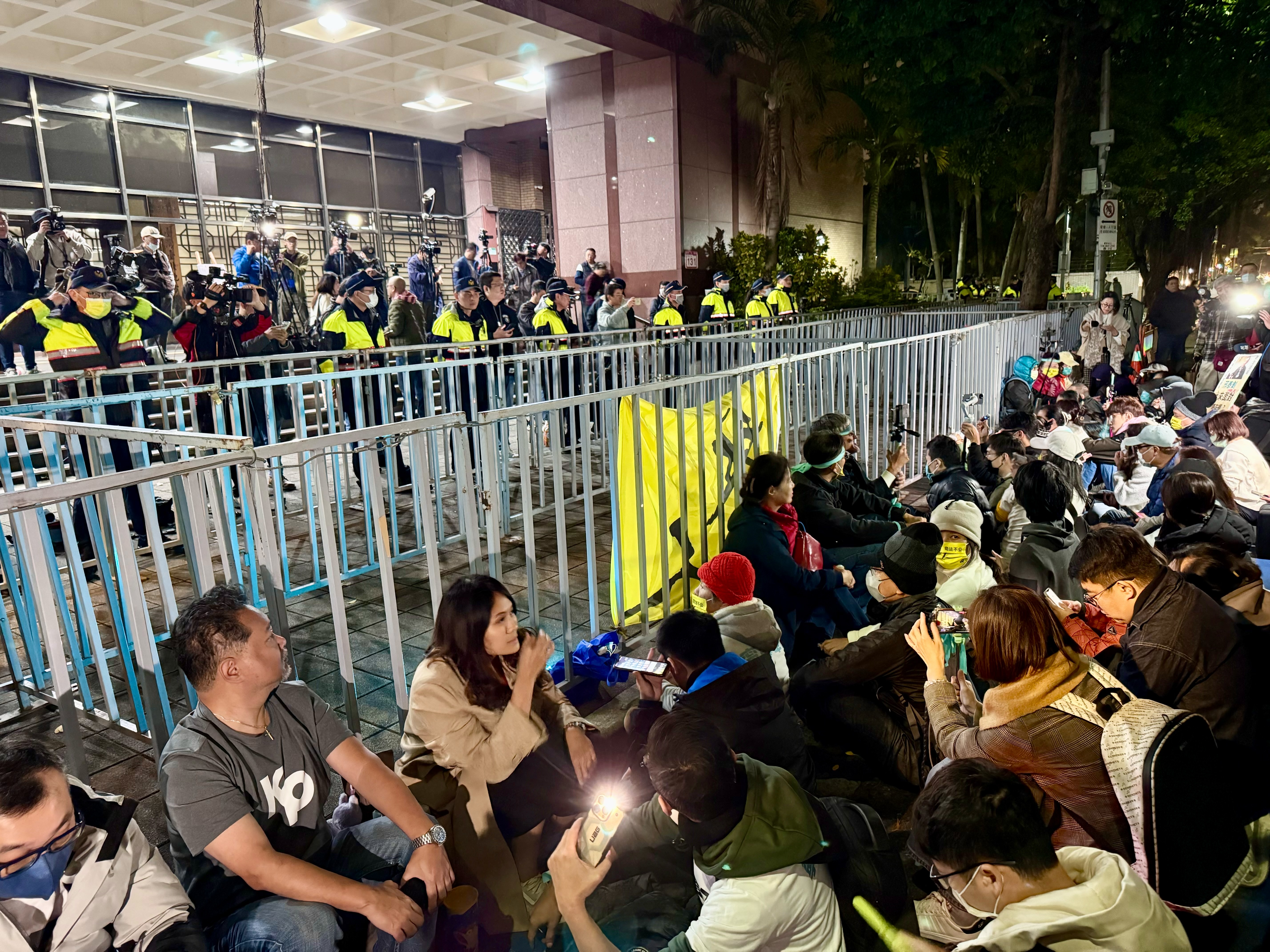 民眾黨組織部宣布6點發動「北檢前集結」，如今陸續有支持者到場，手勾手席地而坐。