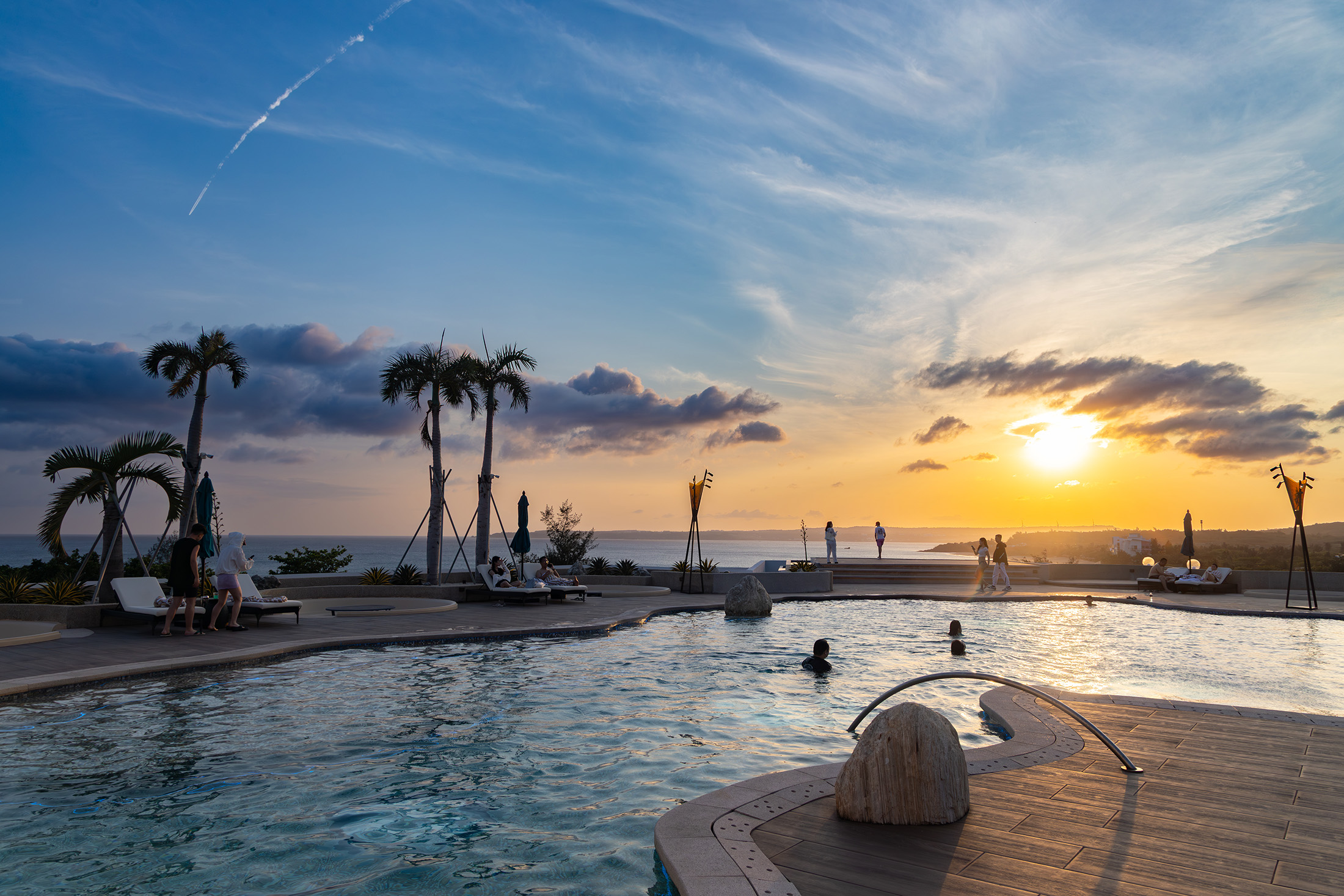 傍晚時分，在「Hotel dùa Kenting」頂樓泳池畔能欣賞到夕陽從遠方緩慢沉入海平面，天空被染成橘紅色的夢幻晚霞。
