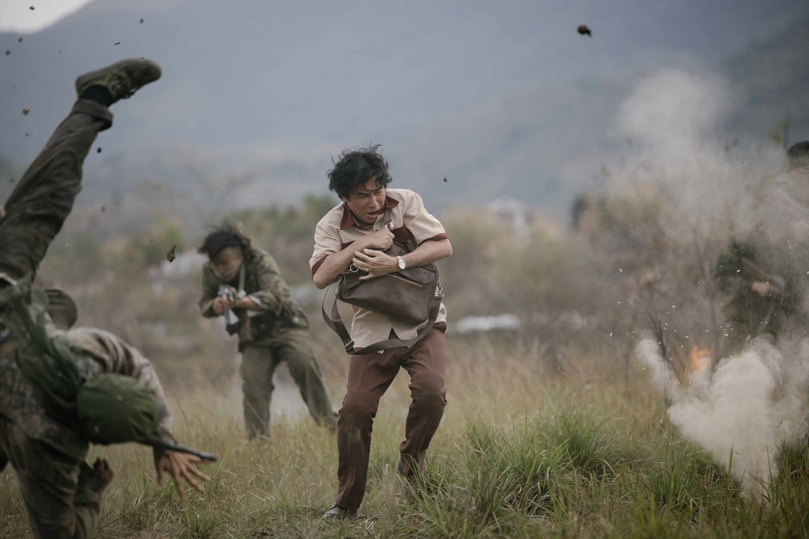 梁朝偉片中抱著公事包在戰地逃難，拍攝時不禁直呼好累。（龍祥提供）