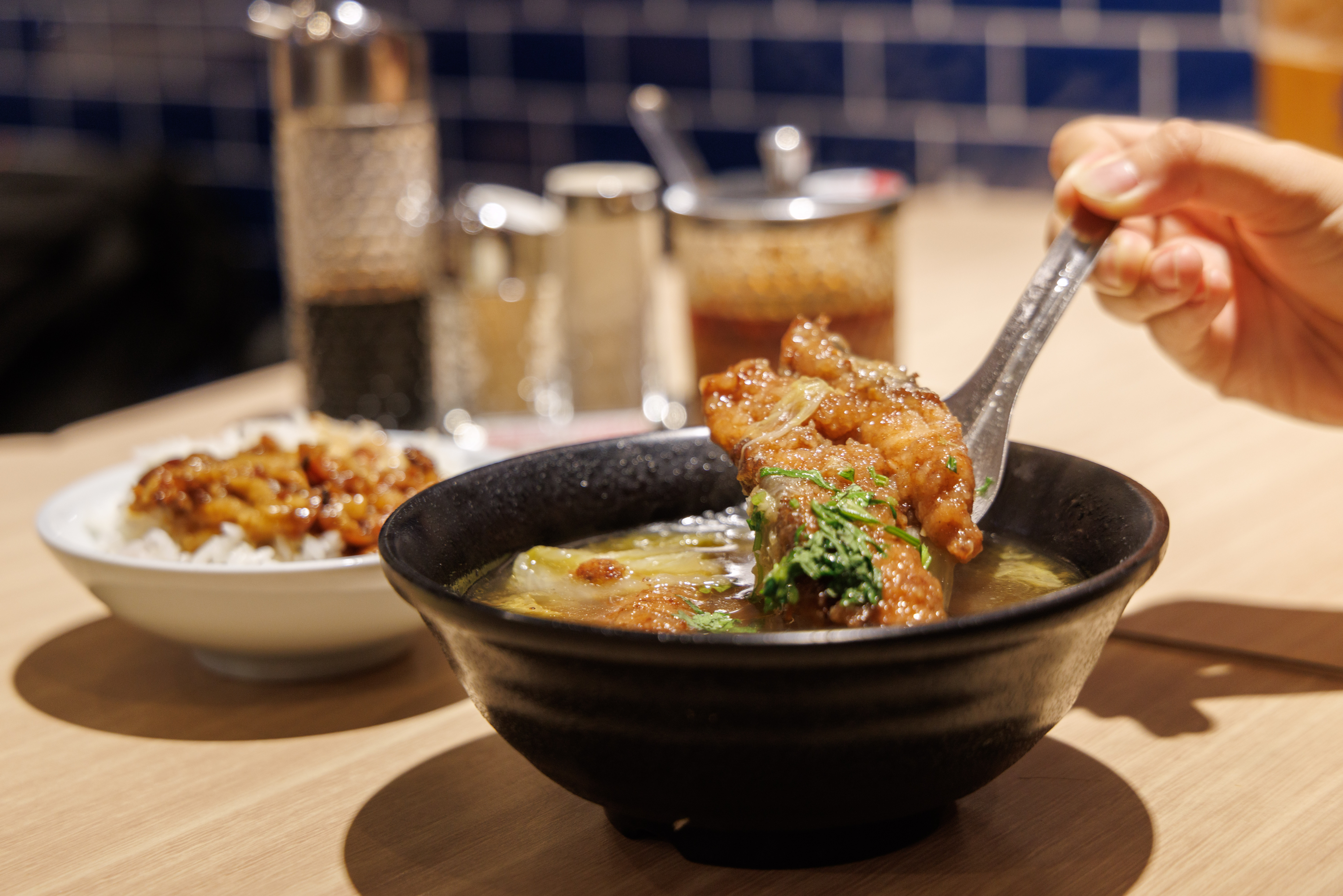 「紅燒鰻焿」（前，75元／碗）是基隆夜市中的豪華小吃，加一碗「魯肉飯」（後，20元／碗）更有飽足感。