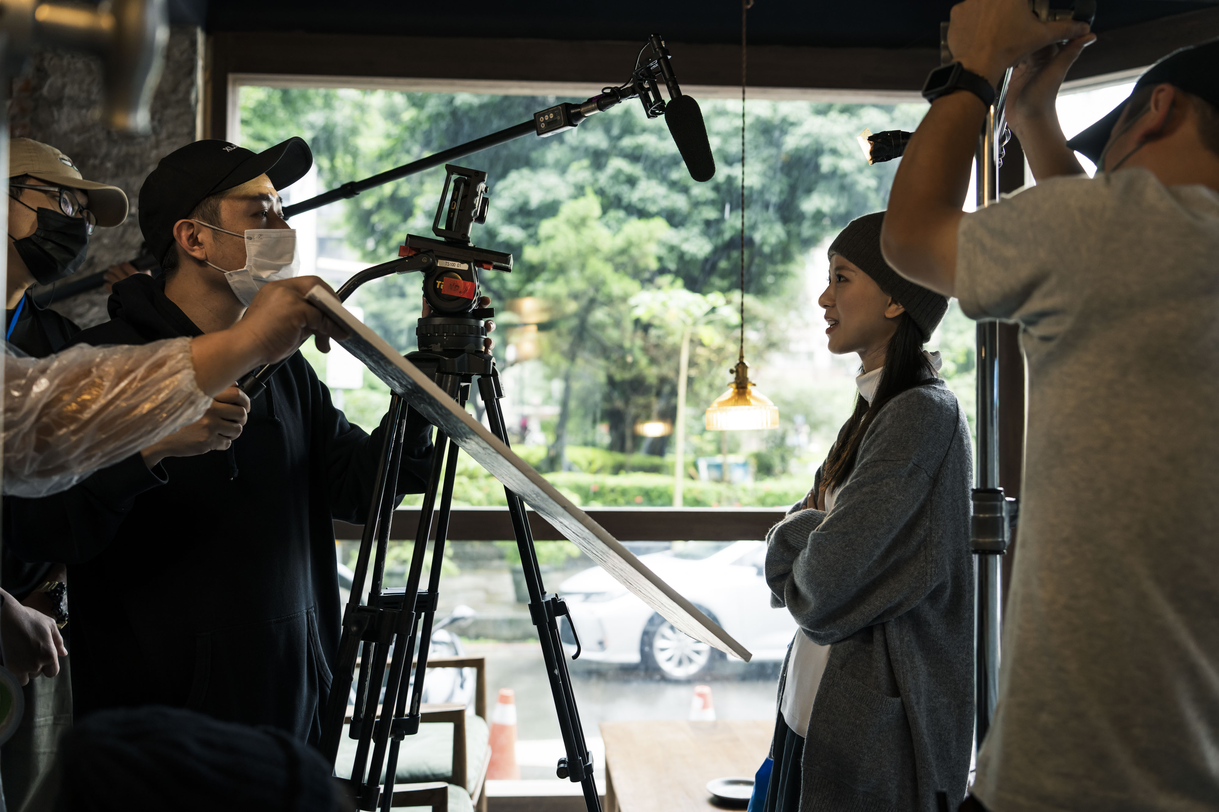 項婕如（右）演出的咖啡店戲，因窗外的雨時有時無讓導演廖明毅（左）傷腦筋。（華映提供）