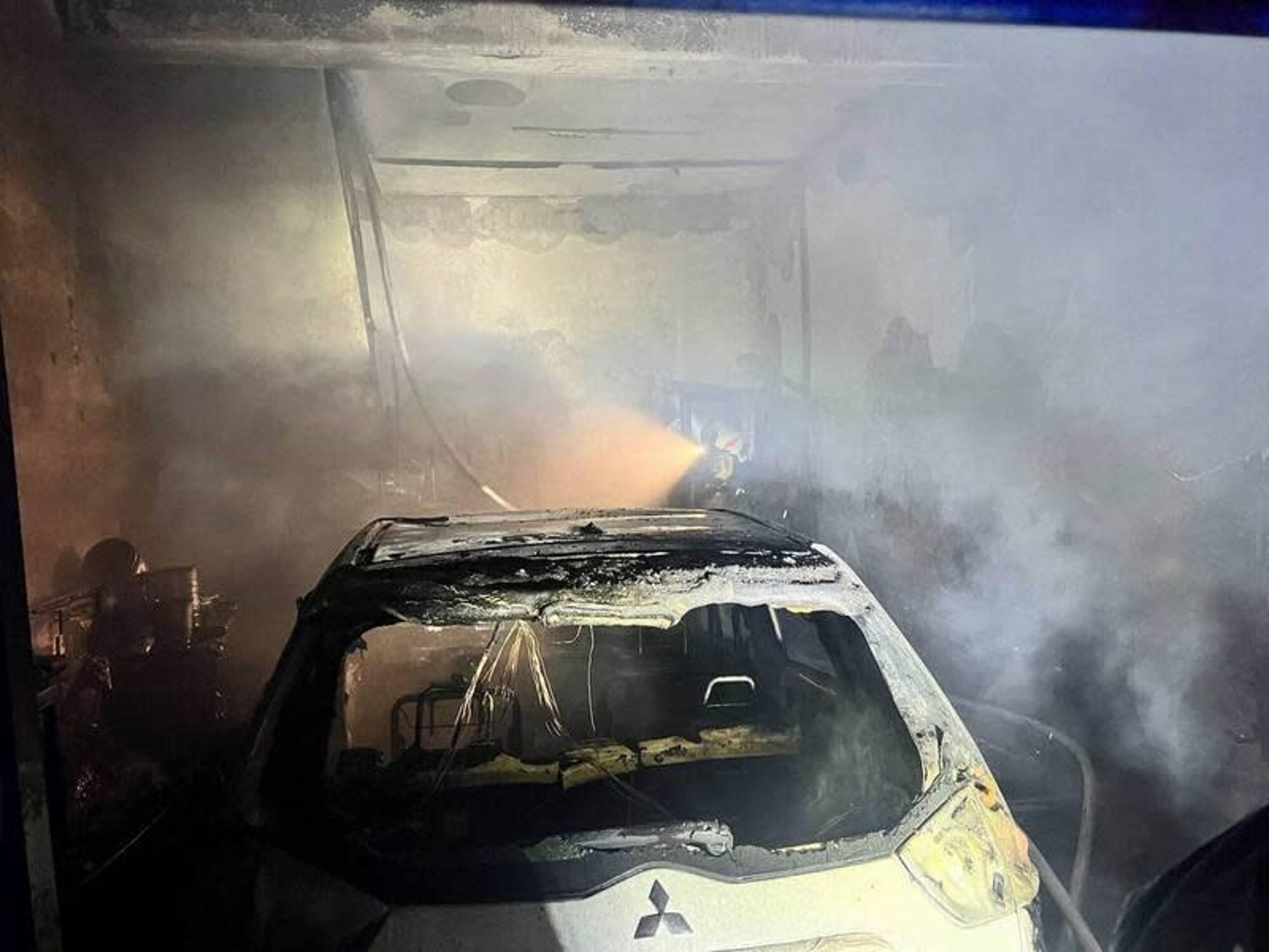 30多歲的男子酒駕開車衝入前妻娘家,引發火燒車,警方將人救出送醫,並撲滅火勢,但車輛已嚴重被燒毀。(翻攝畫面)