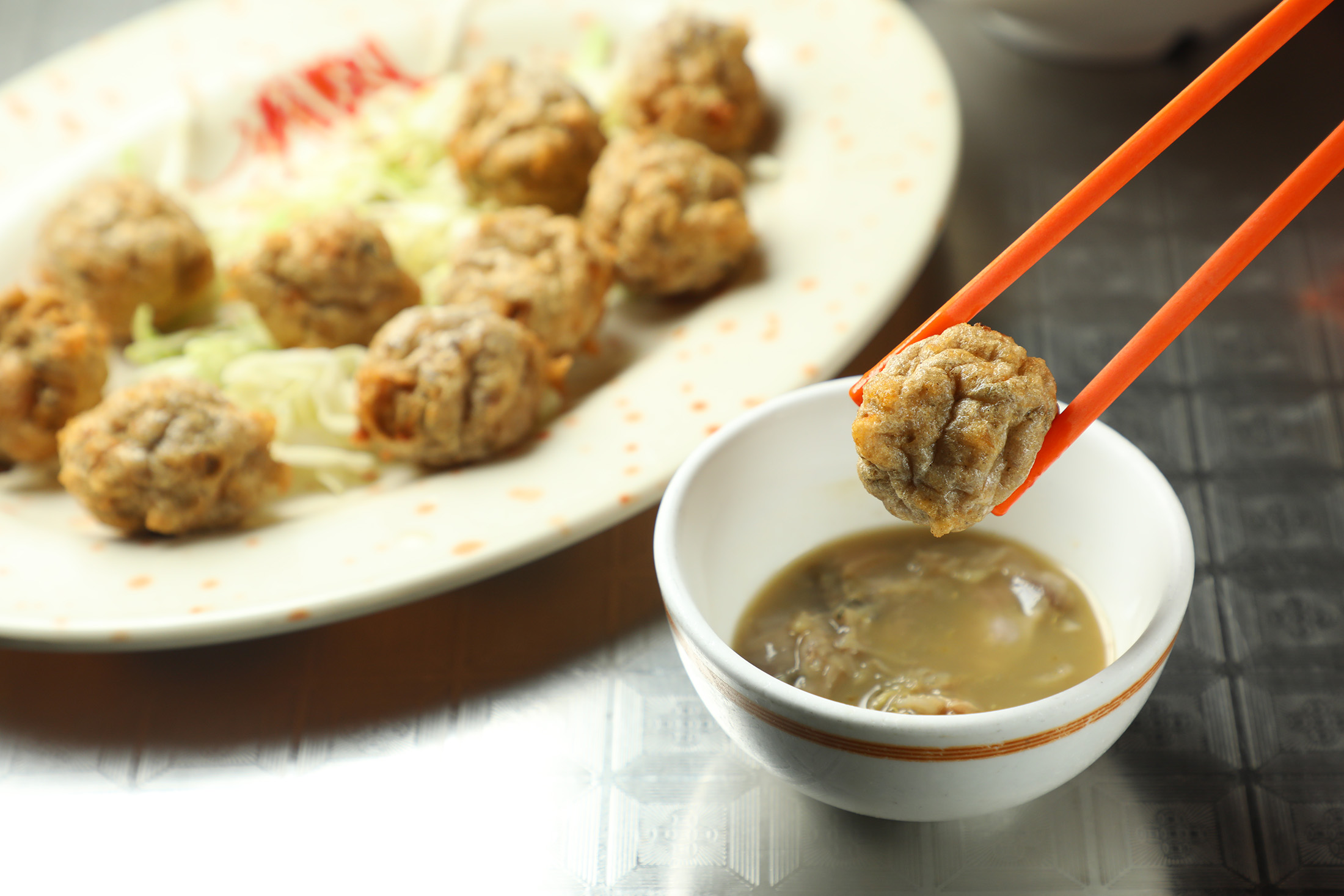 傳統港式小食「酥炸鯪魚球」外酥內嫩，魚肉彈牙鮮甜，搭配以泥蜆、汾酒與陳皮醃製的「蜆蚧醬」，風味層次更豐富。（港幣88元／份，約NT$340）
