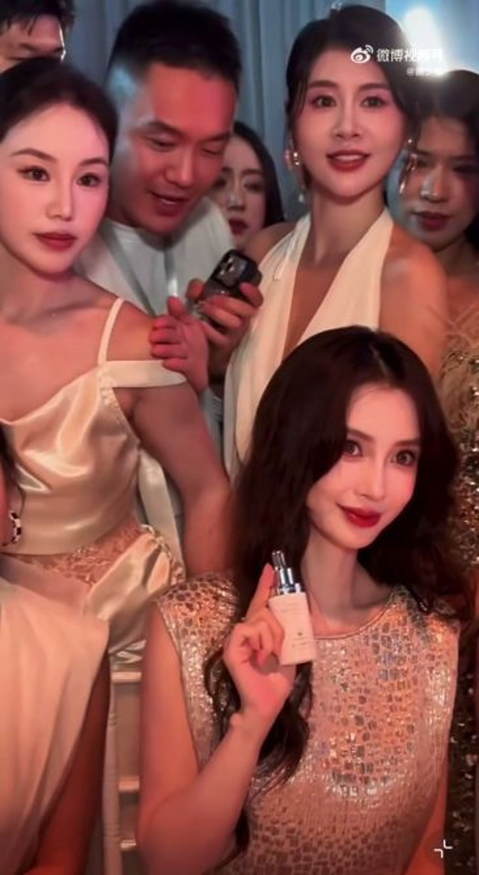 Angelababy身後的男士硬要擠來前面與女神同框，但被他排擠的金禮服女士防守嚴密，一點機會都不給他。（翻攝微博影片）