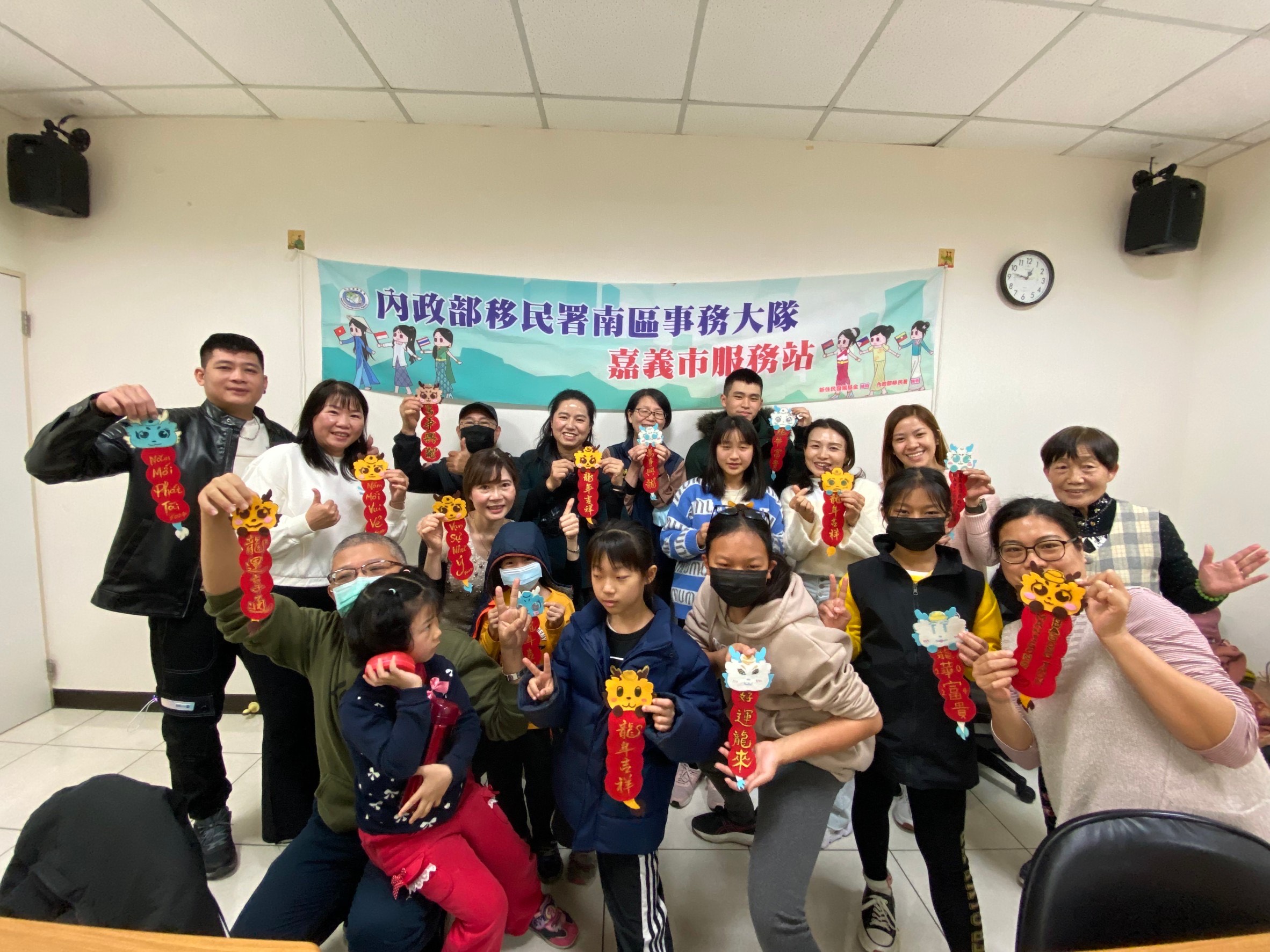 參與民眾開心地拿著春聯合影。（移民署提供）