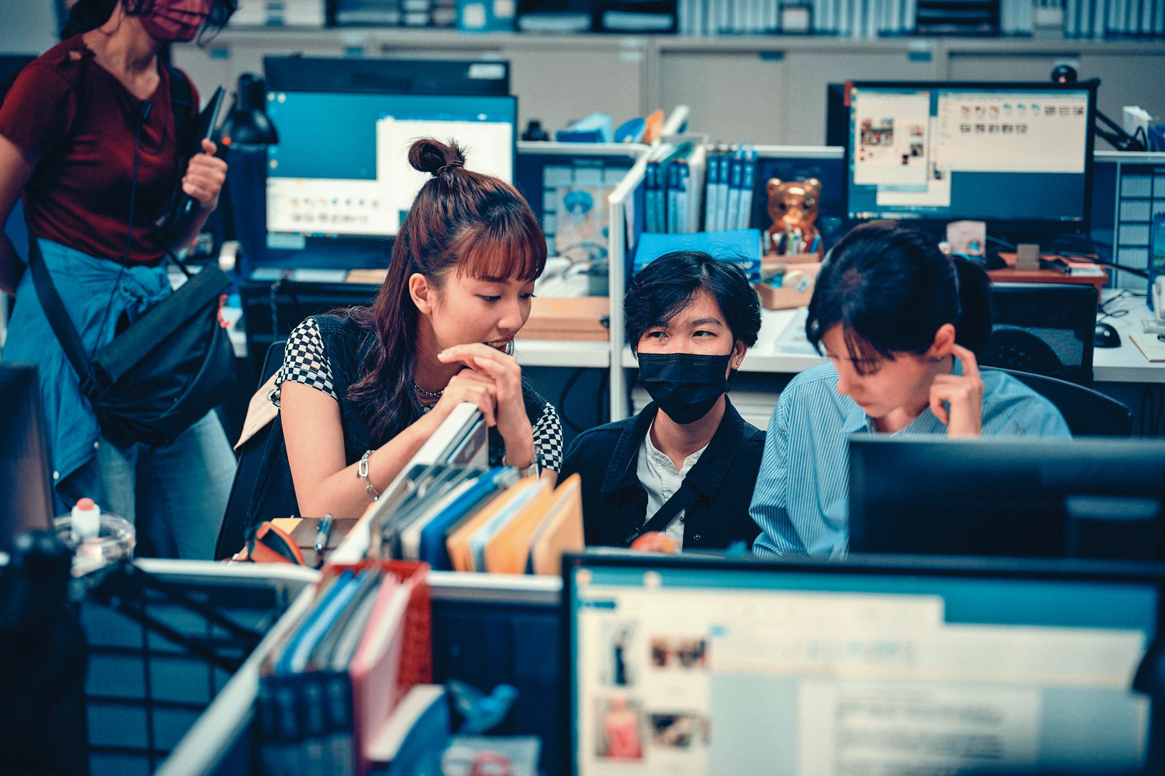 導演梁秀紅(中)與演員林予晞(右)及王渝萱(左)在拍攝現場討論劇本。(鏡文學提供)