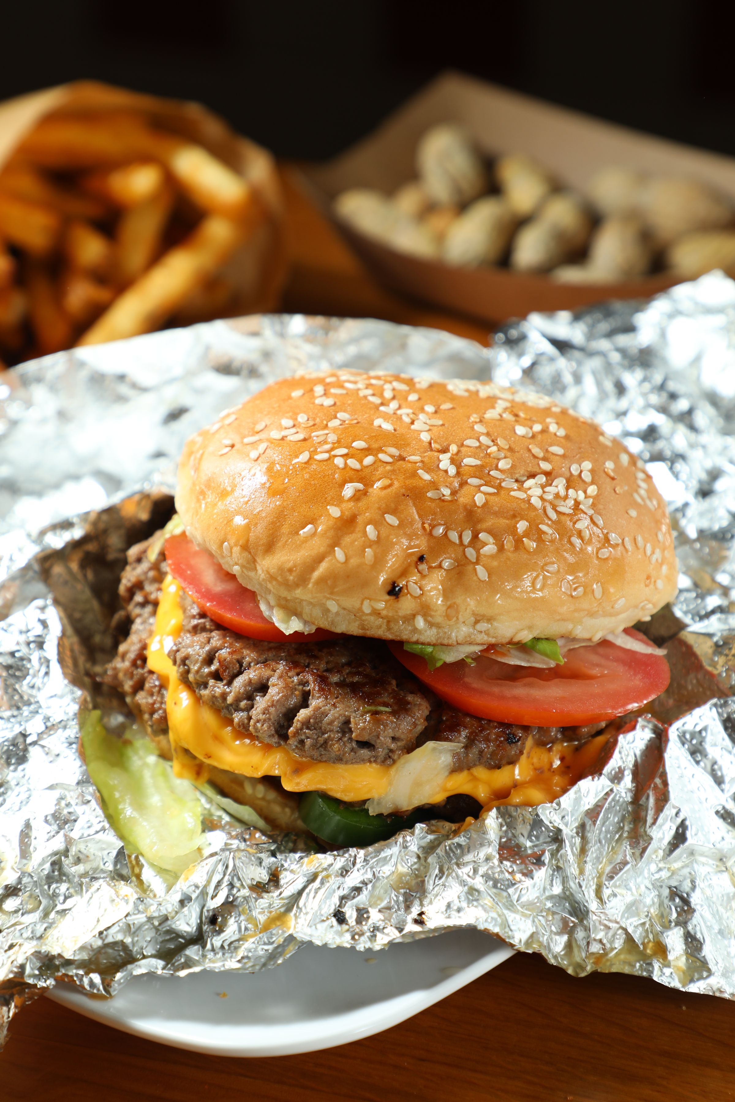 雙層起士漢堡「Cheeseburger」（前，港幣95元／個）可免費組合15種配料，搭配肯瓊口味辣薯條「Fries」（後，港幣48元／小份）。