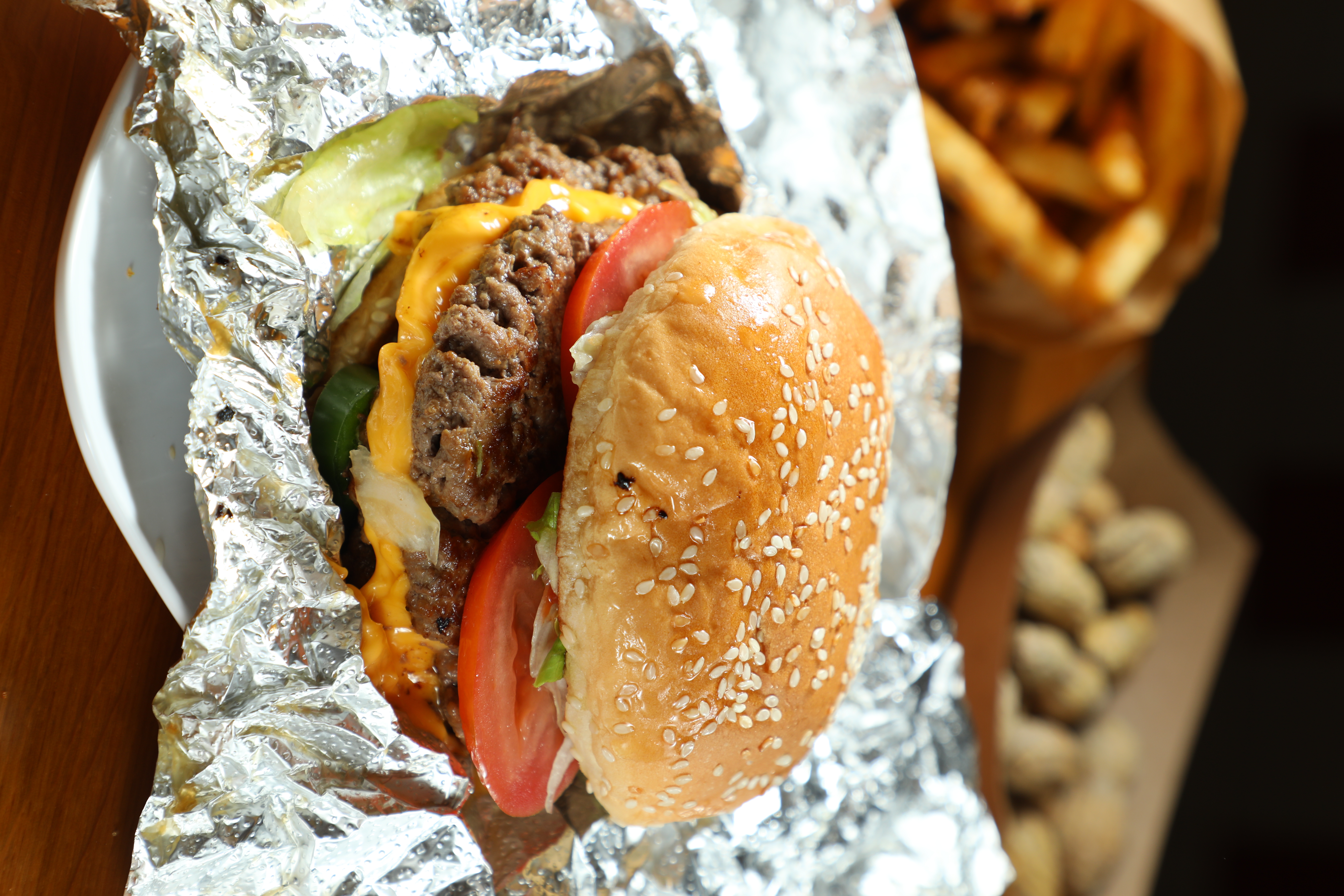 雙層起士漢堡「Cheeseburger」(前,港幣95元/個)可免費組合15種配料,搭配肯瓊口味辣薯條「Fries」(後,港幣48元/小份)。