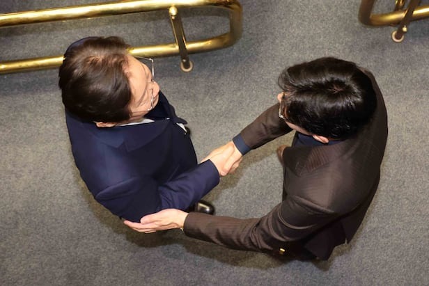 韓東勳(右)與李在明雙方握手,兩大黨難得同框合作。(翻自《朝鮮日報》)