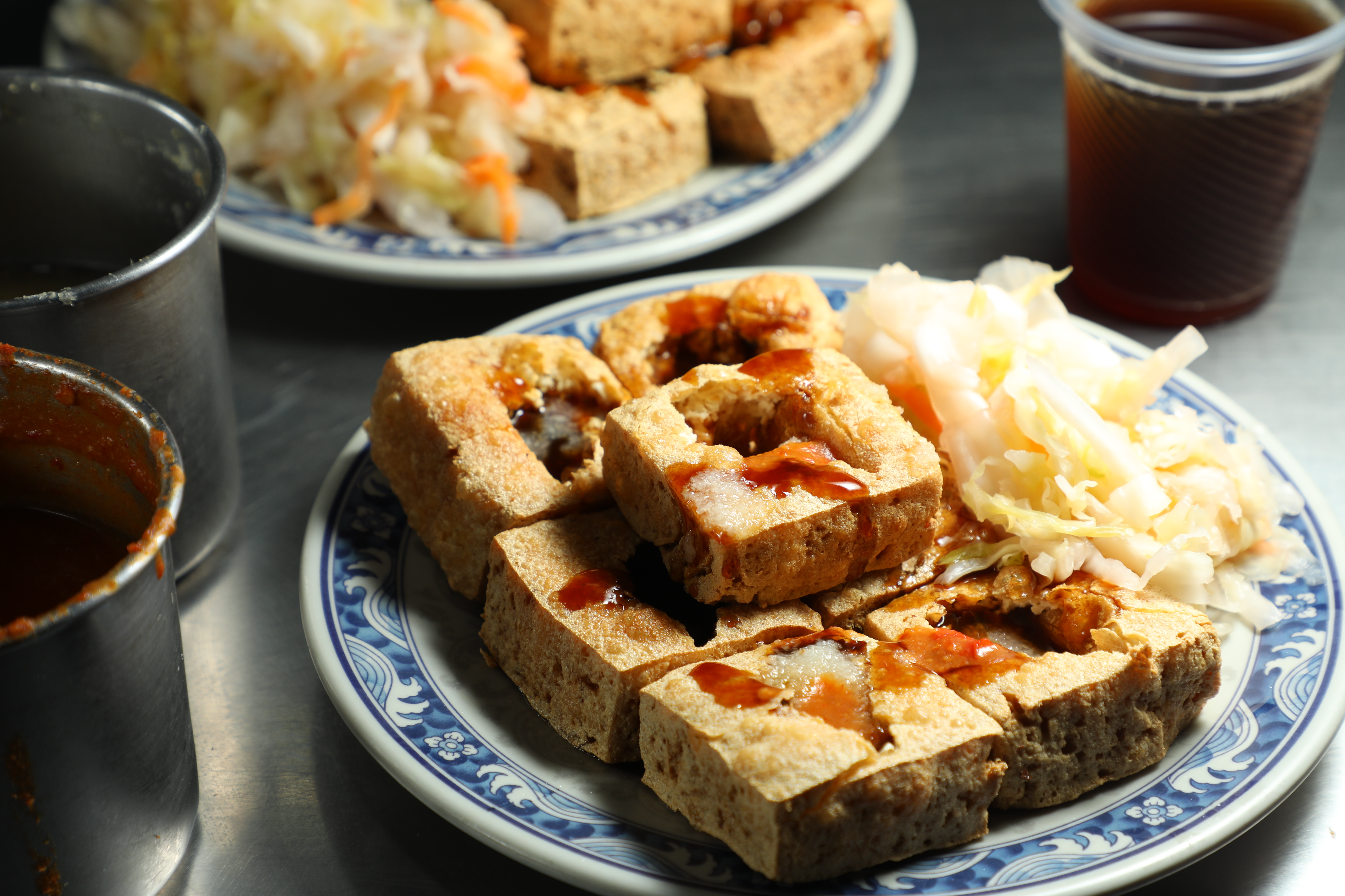 臭豆腐中間有打孔，方便醬汁滲入，一定要加上滿滿的蒜泥醬與辣椒醬，配上泡菜，真是一絕。（70／5塊、80／6塊、90元／7塊）