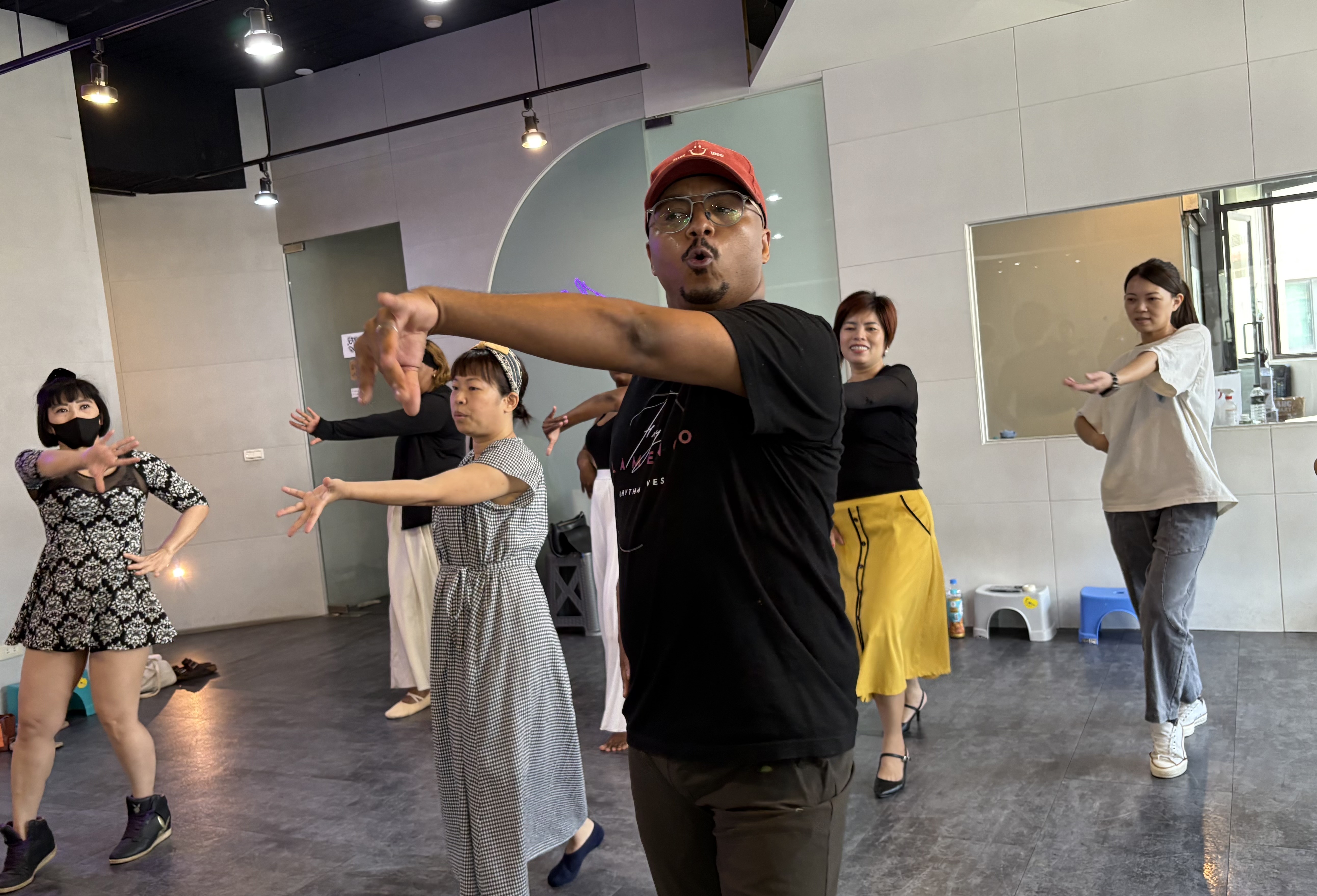 講師Ndumiso帶領參與民眾練習手部轉腕的動作。（移民署提供）