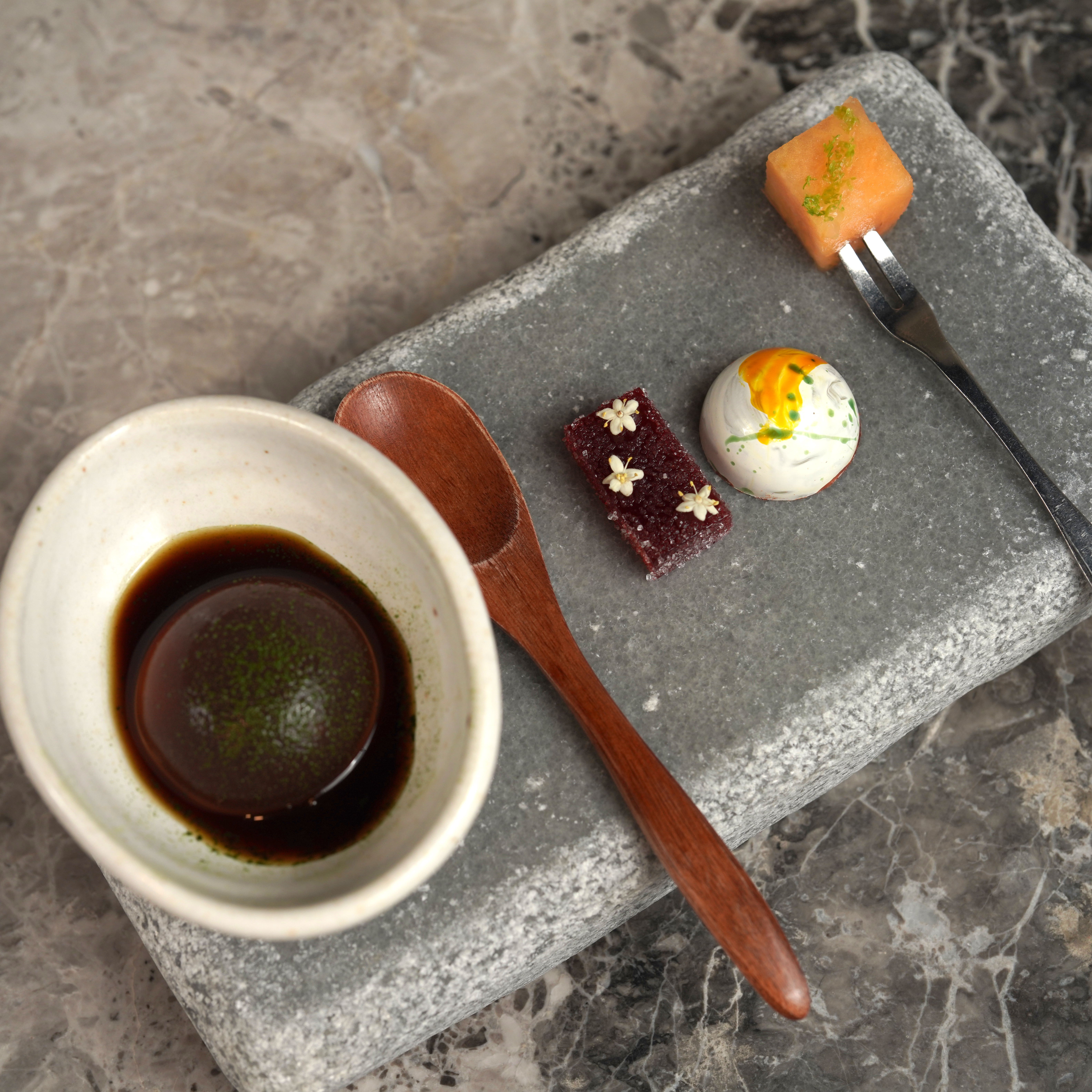 餐後茶點Mignardises是抹茶黑糖愛玉、法式覆盆莓軟糖、清酒酒麴巧克力及新鮮哈密瓜搭配清酒凍,非常清爽。(蘭餐廳提供)