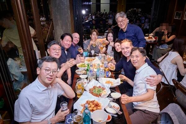 黃敏珊(右三)及未婚夫Nico Caprez(右二)、崔允禎夫妻(中)、崔泰源(左三)等人同桌吃炸雞。(翻攝SK Telecom)