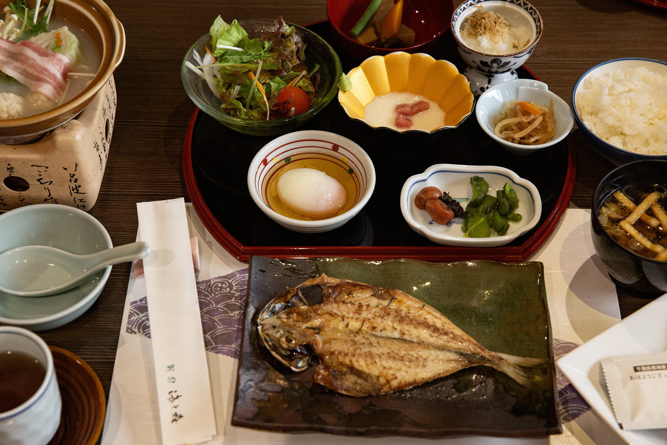 旅館的日式早餐內容豐富，除了各種小菜，還有一夜干、兩種湯品等。