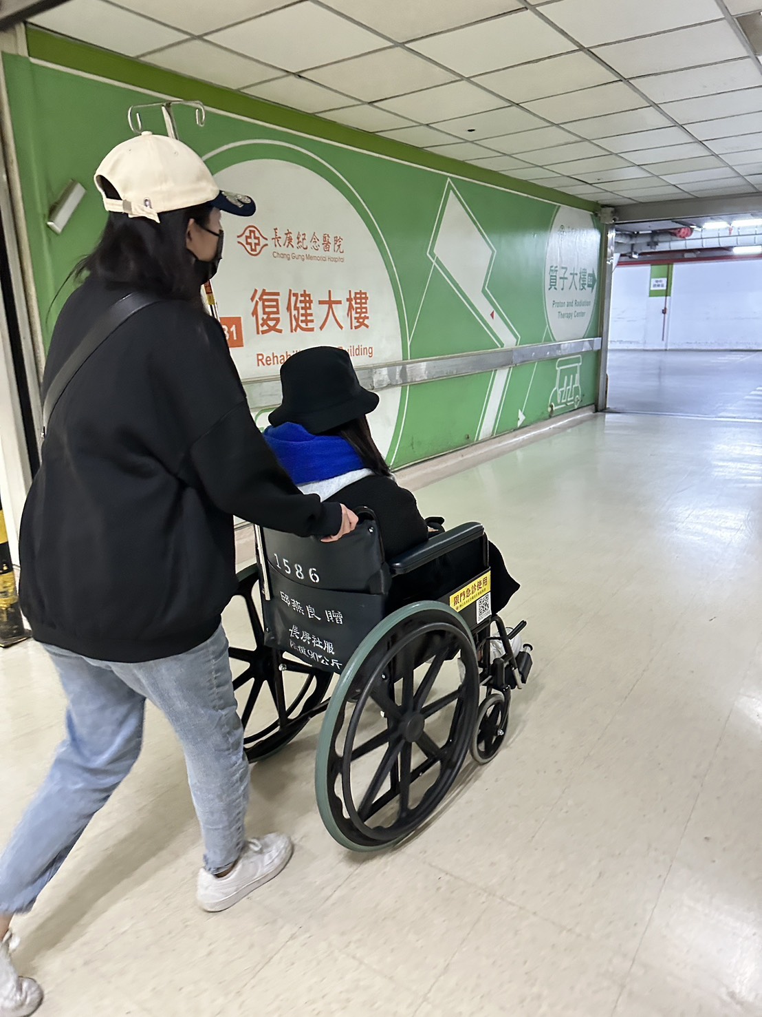 曉筠在親友協助下，速度緩慢往醫院停車場方向。（讀者提供）
