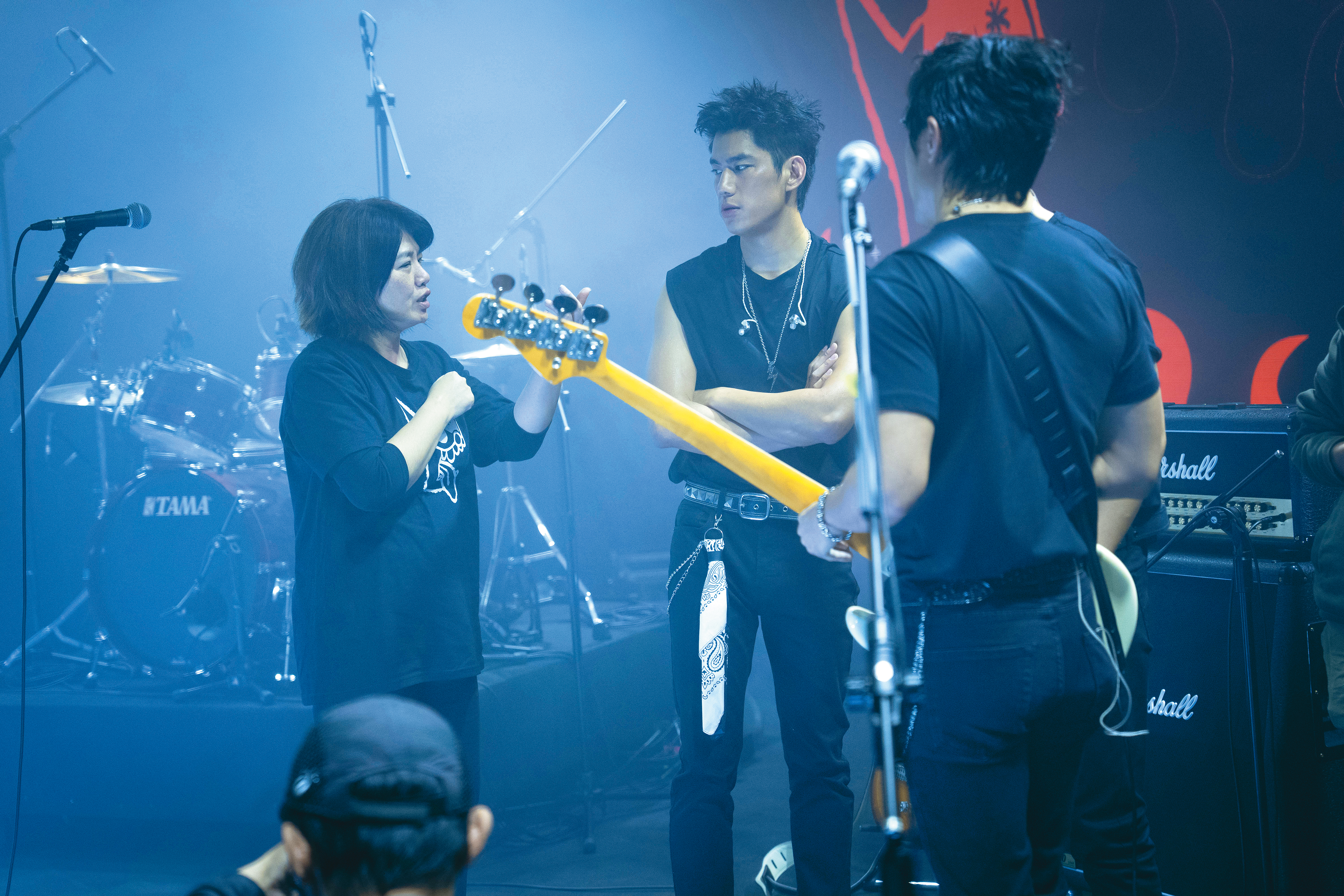導演嚴藝文（左）與朱軒洋（中）在拍演唱會場面時密集溝通。（公視提供）