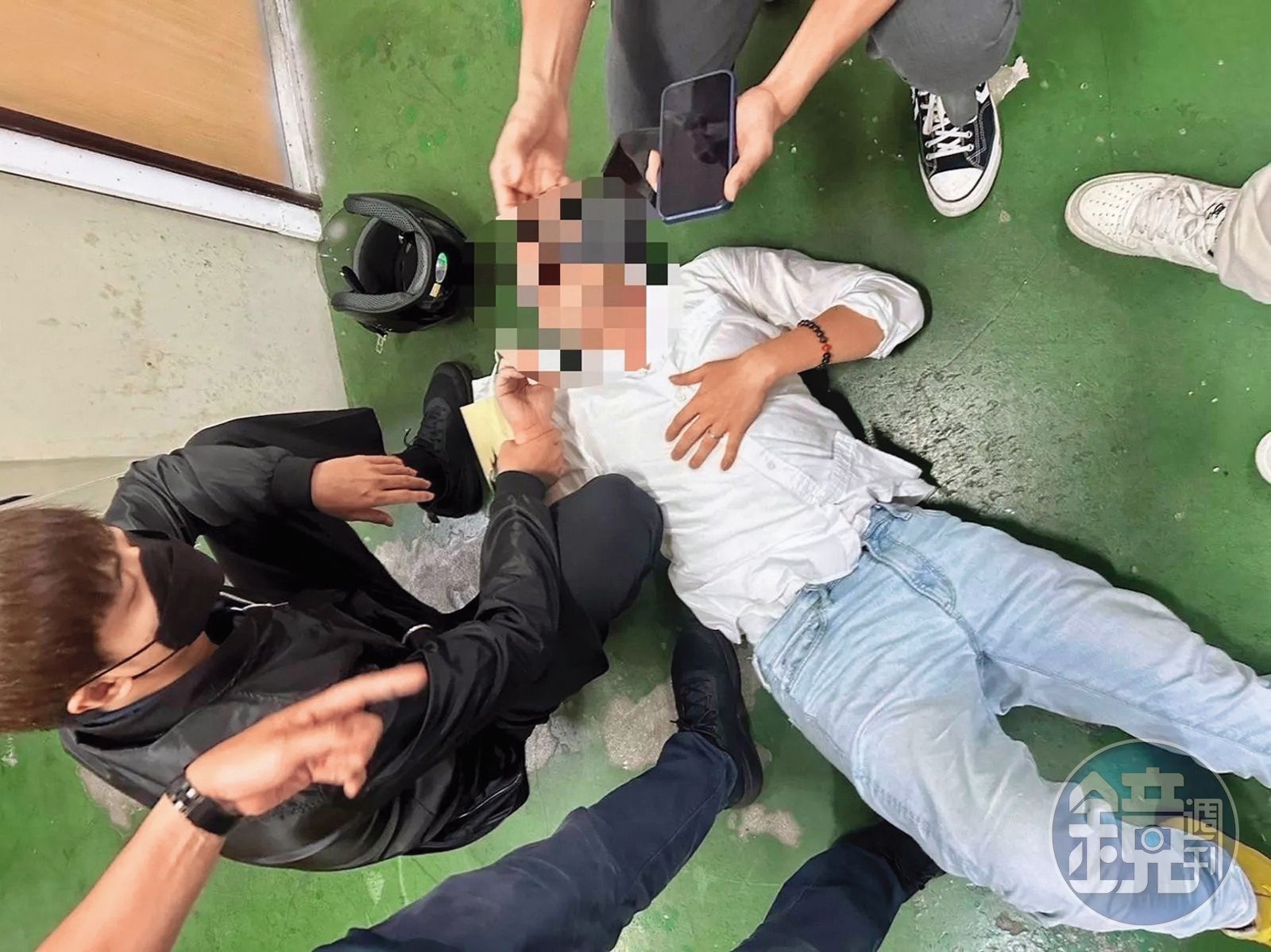 陳鑒在新北板橋火車站遭警方壓制在地，畫面狼狽。（讀者提供）