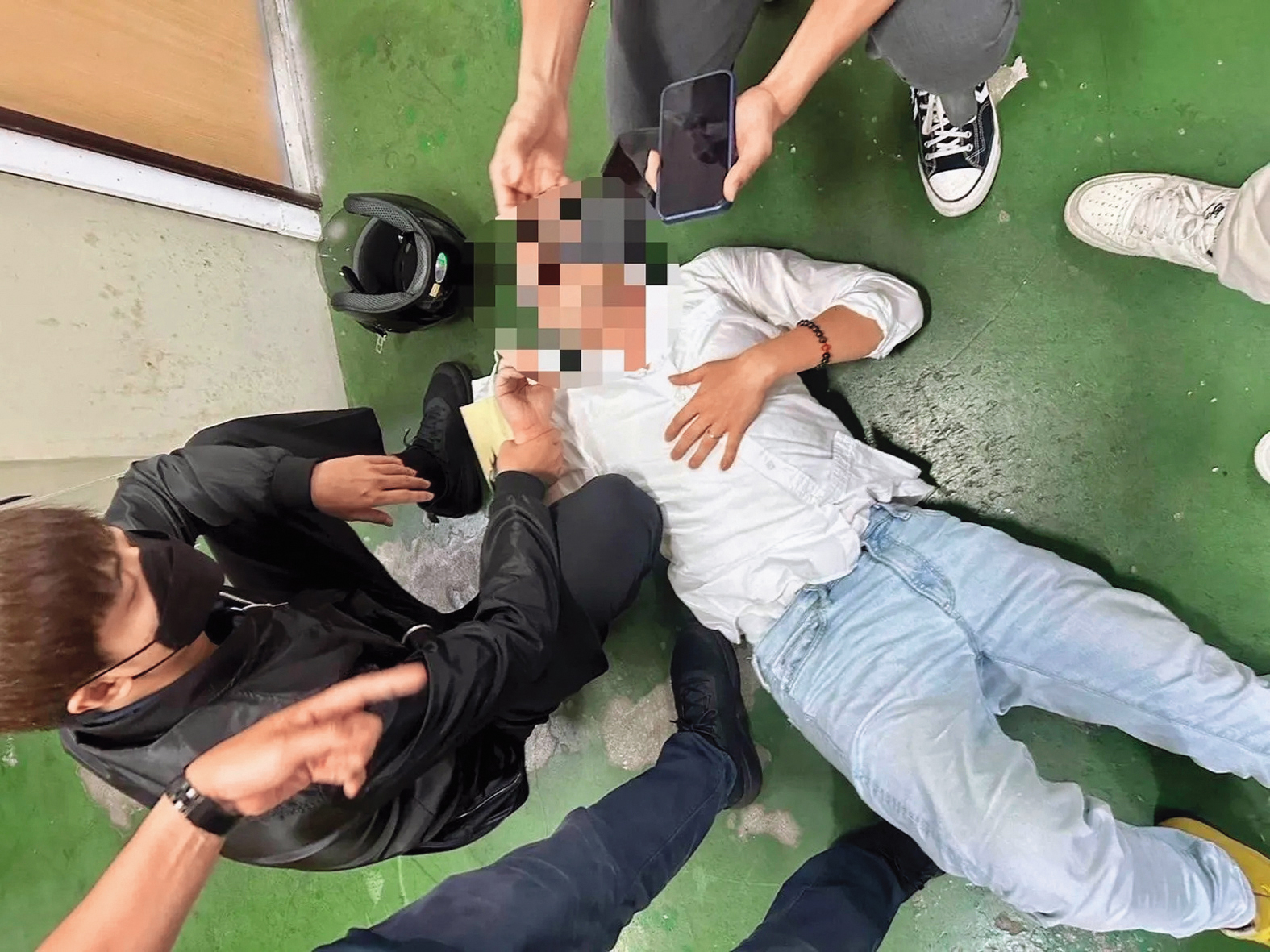 陳鑒在新北板橋火車站遭警方壓制在地，畫面狼狽。（讀者提供）