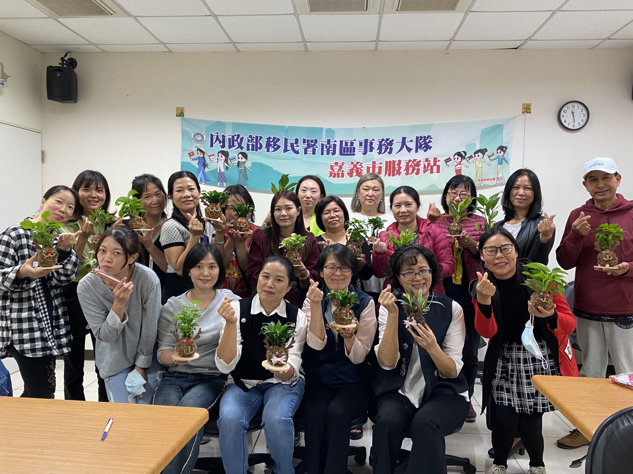 參與民眾開心地拿著自己做的耶誕苔球合照,提前歡度耶誕節。(移民署提供)