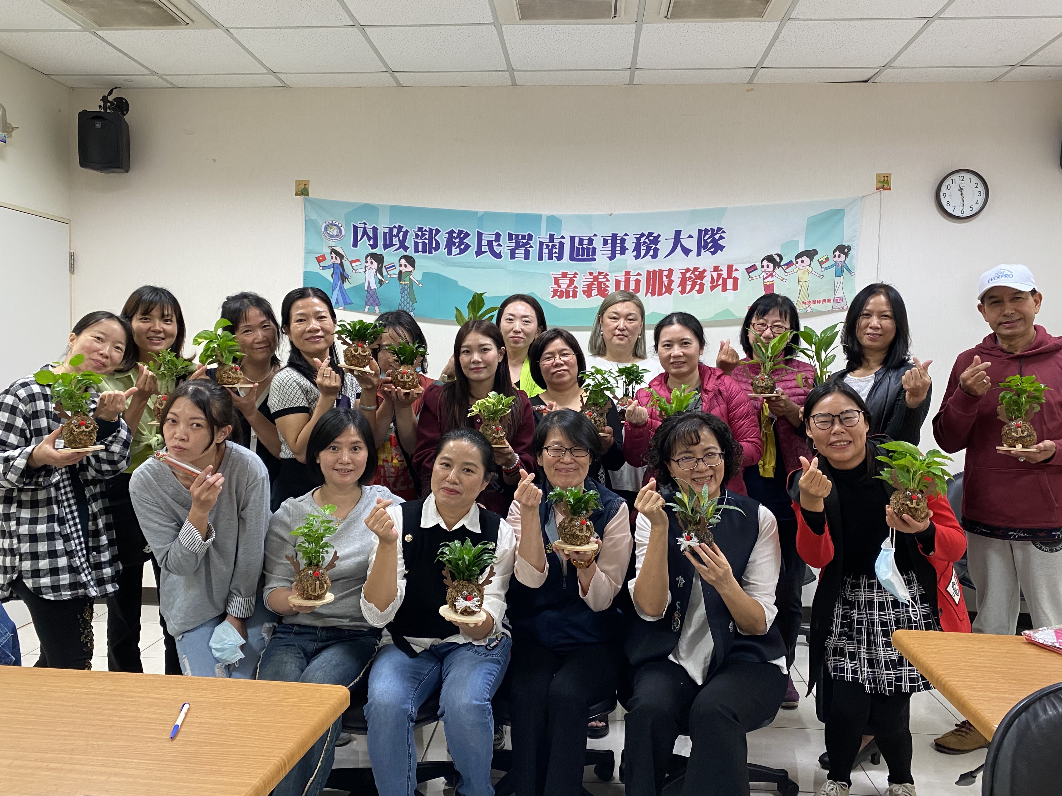 參與民眾開心地拿著自己做的耶誕苔球合照，提前歡度耶誕節。（移民署提供）