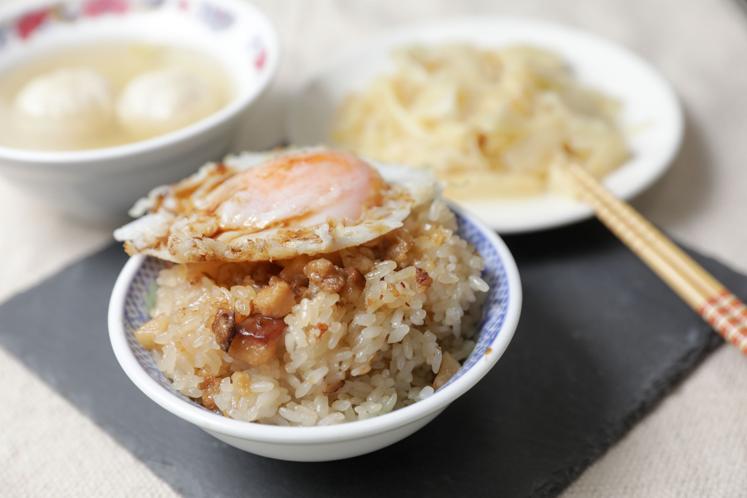 「珠記大橋頭油飯」以油飯搭配半熟荷包蛋，是最經典的吃法。（攝影／林煒凱）