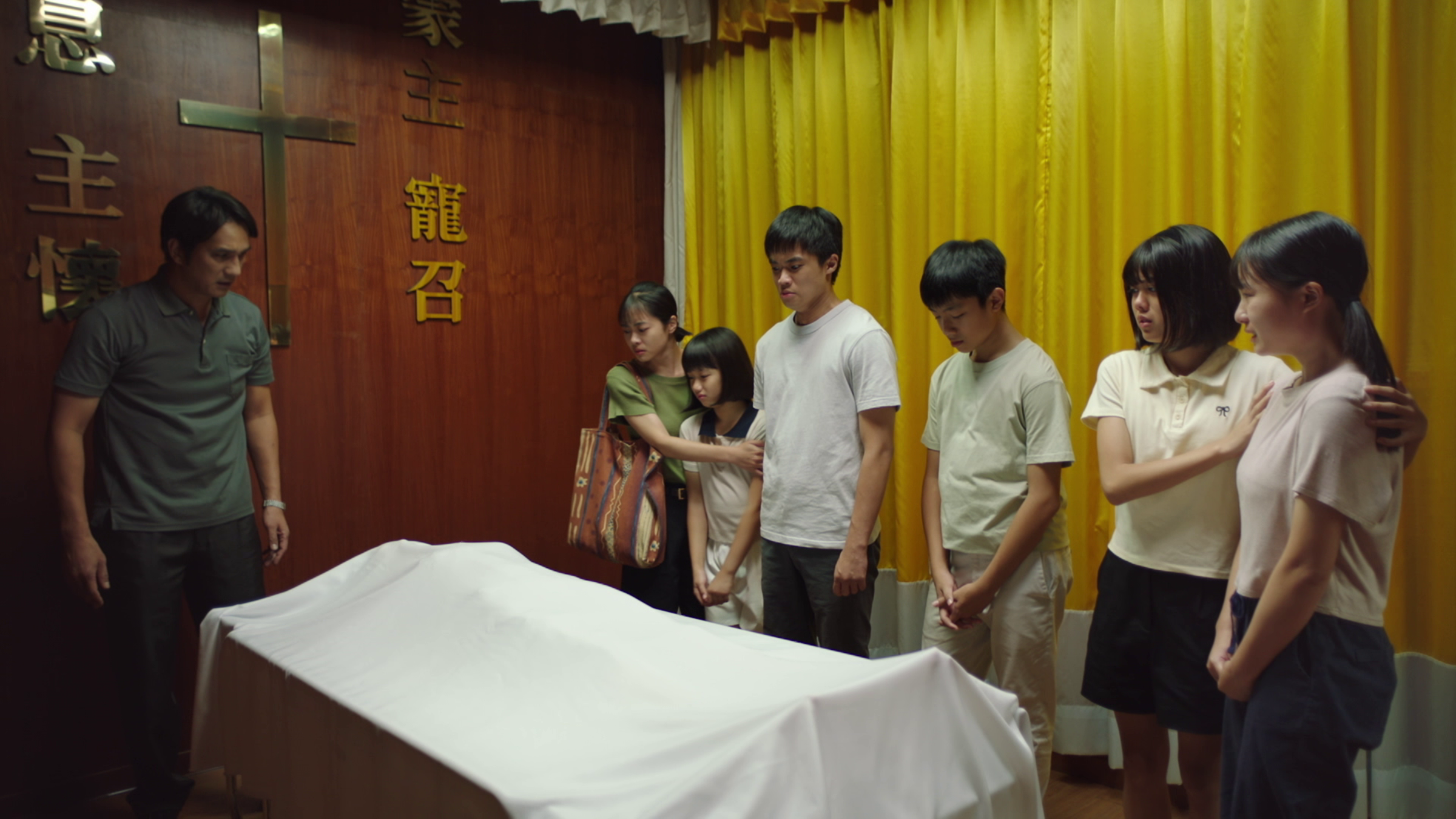 天心在太平間親自演屍體,戲裡老公馬志翔跟六個孩子哀傷萬分。(大愛提供)