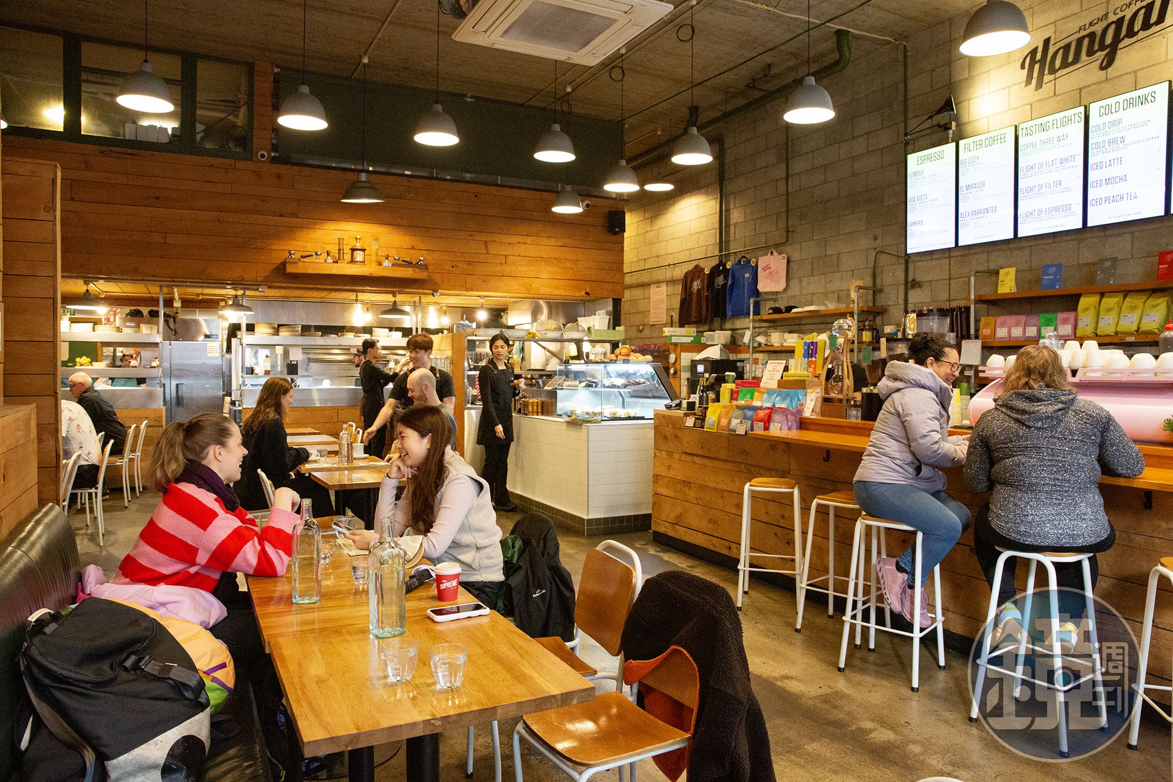 前身為室內停車場的The Flight Coffee Hangar,保留挑高空間、裸露磚牆與地面停車格線,營造鮮明的工業風格。