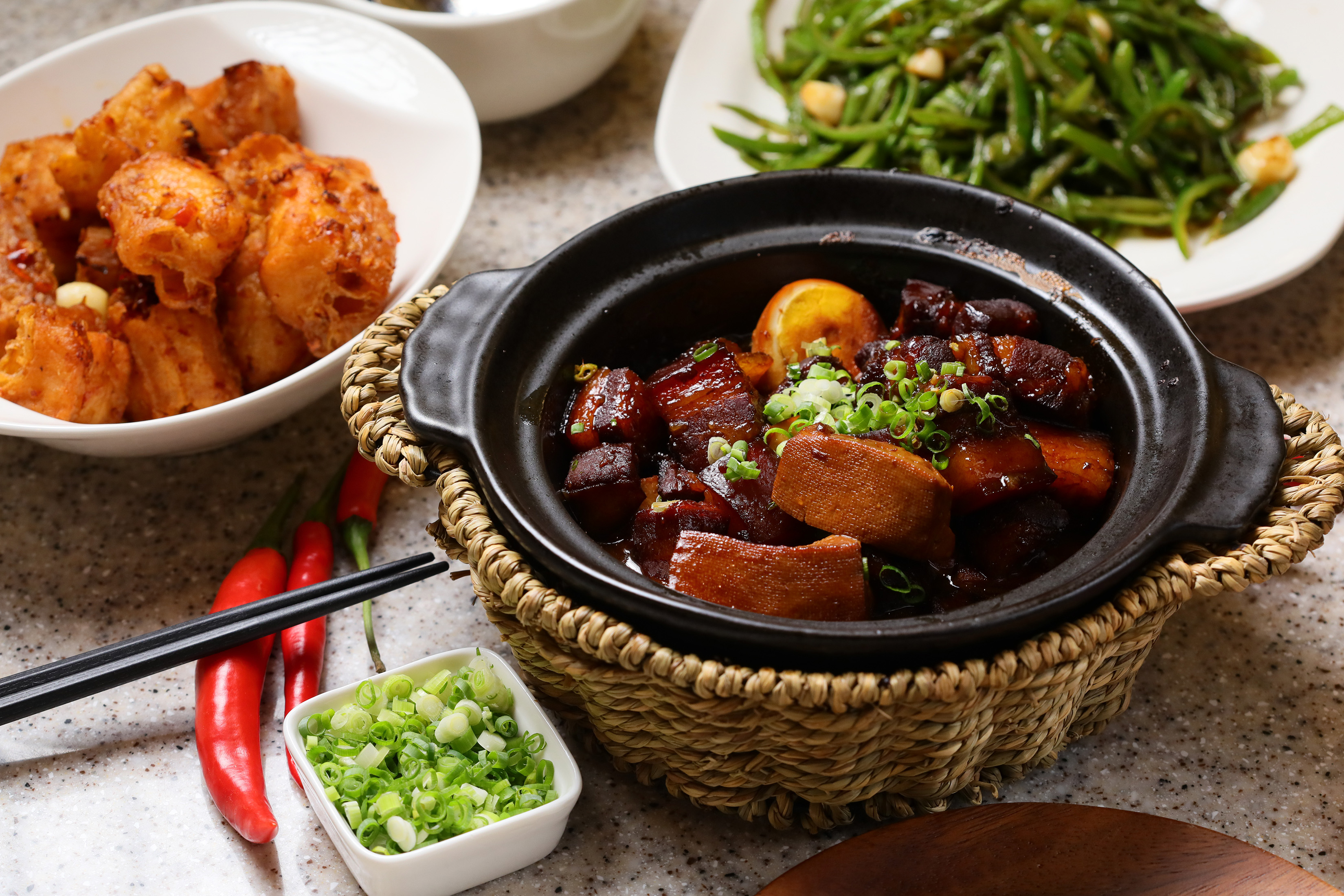 「炒糖紅燒肉燜豆腐」是知名的不辣湘菜代表（前，398元／份），「爆炒青椒扁豆絲」（右後，288元／份）與「蝦餡百花鑲油條」（左後，298元／份）是炒湘湘的創意菜。
