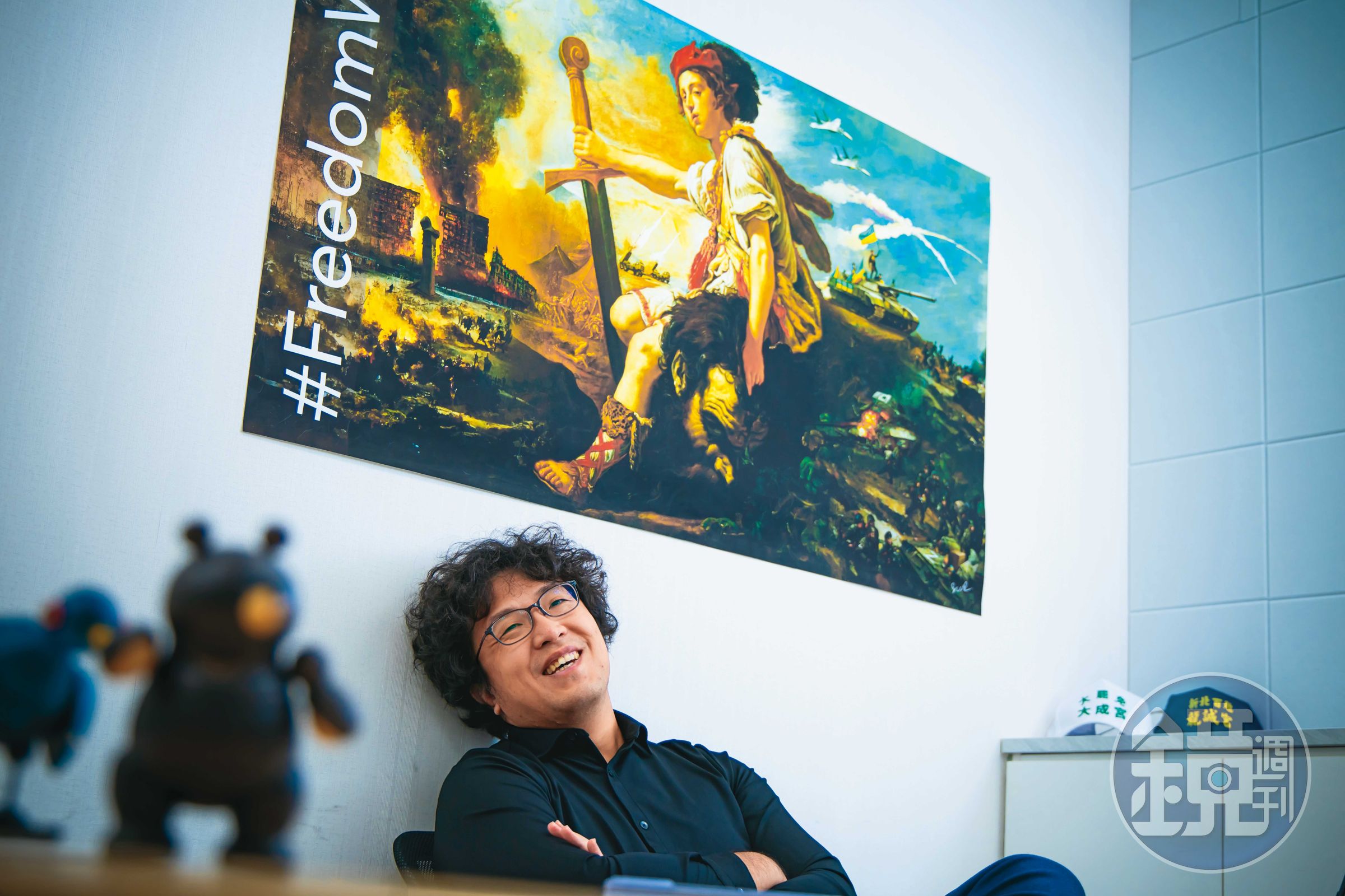 沈伯洋在立法院研究室受訪，辦公室內貼著聲援烏克蘭意象的海報。他一直觀察烏俄戰爭中的虛假訊息與資訊戰。