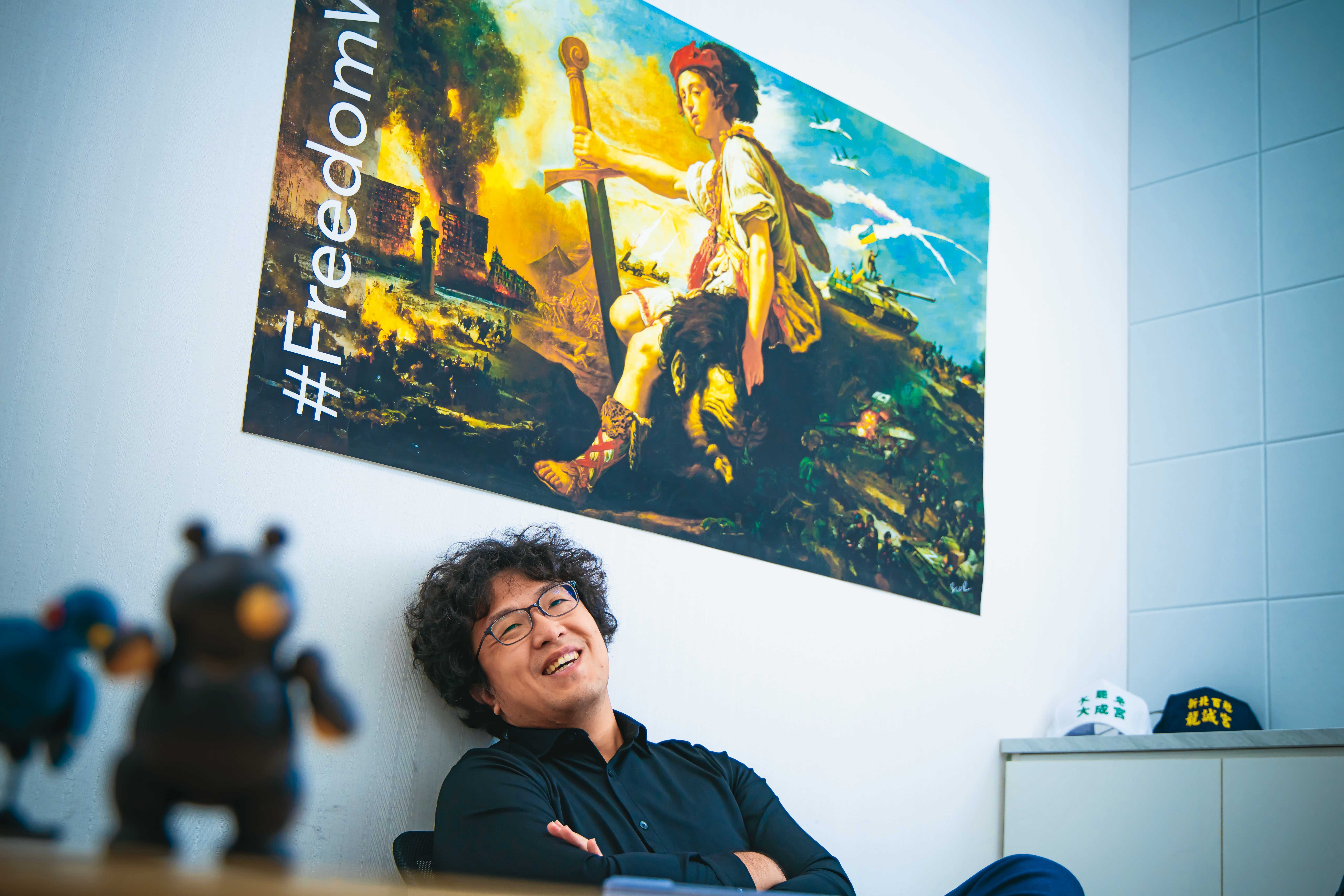 沈伯洋在立法院研究室受訪,辦公室內貼著聲援烏克蘭意象的海報。他一直觀察烏俄戰爭中的虛假訊息與資訊戰。