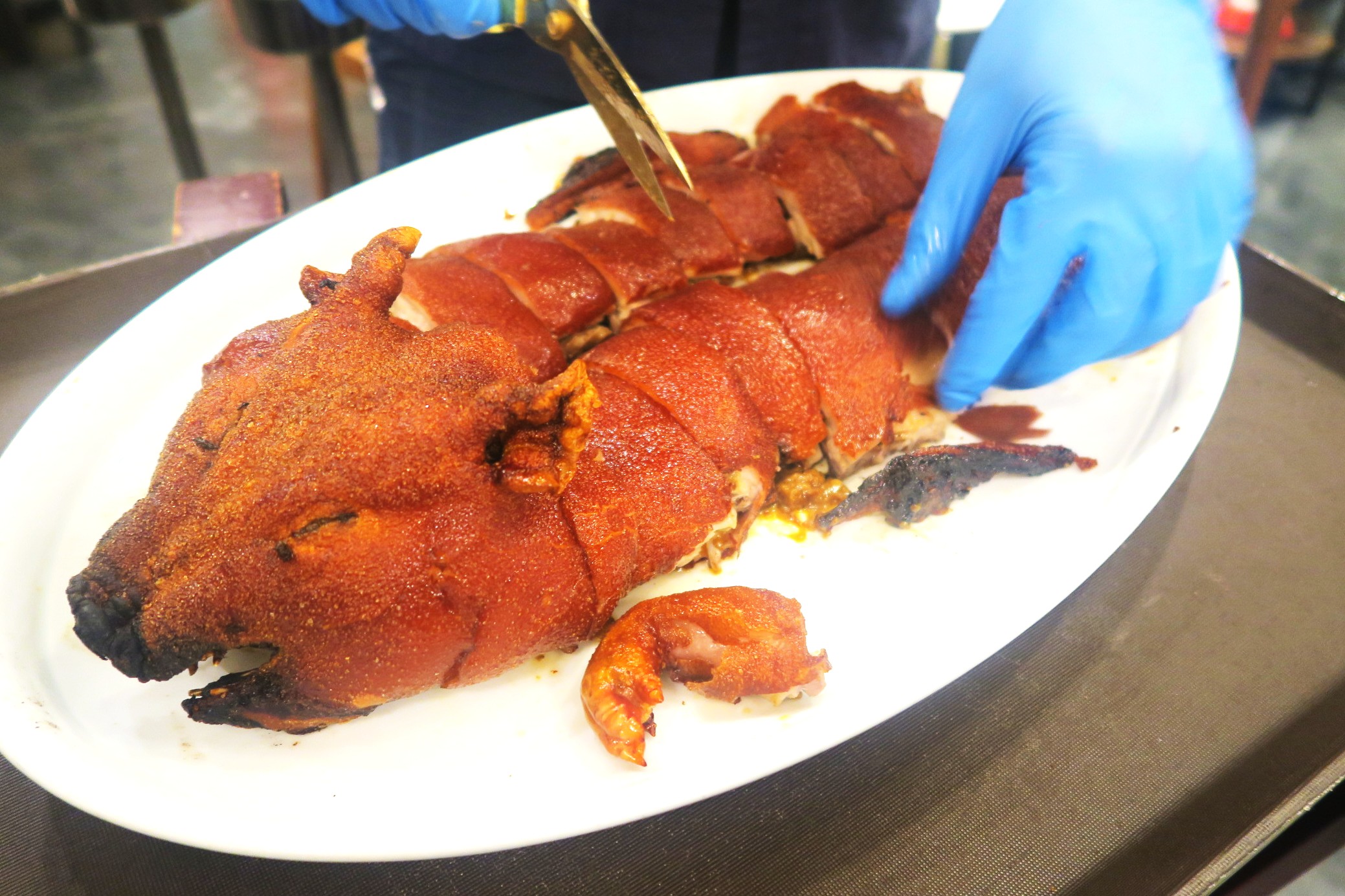 乳豬趁熱連骨剪成一塊塊，迅速分食享用。（堂剪迷你乳豬，港幣888元／隻，約NT$3,599，需預訂）