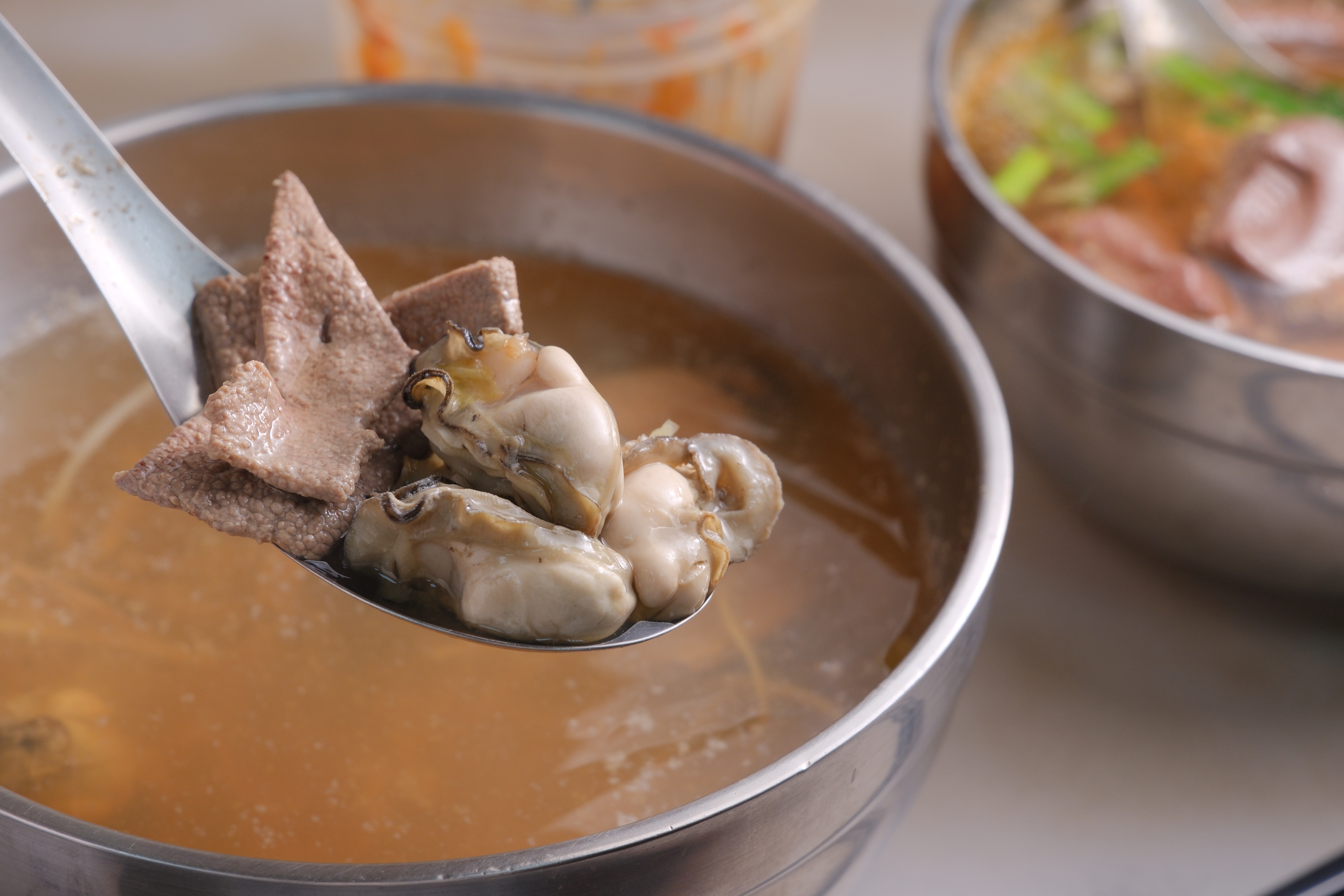 用肥美蚵仔與厚切豬肝熬煮的「海陸湯」,是許多老饕心中不到百元的能量補給。(彭仁義攝)