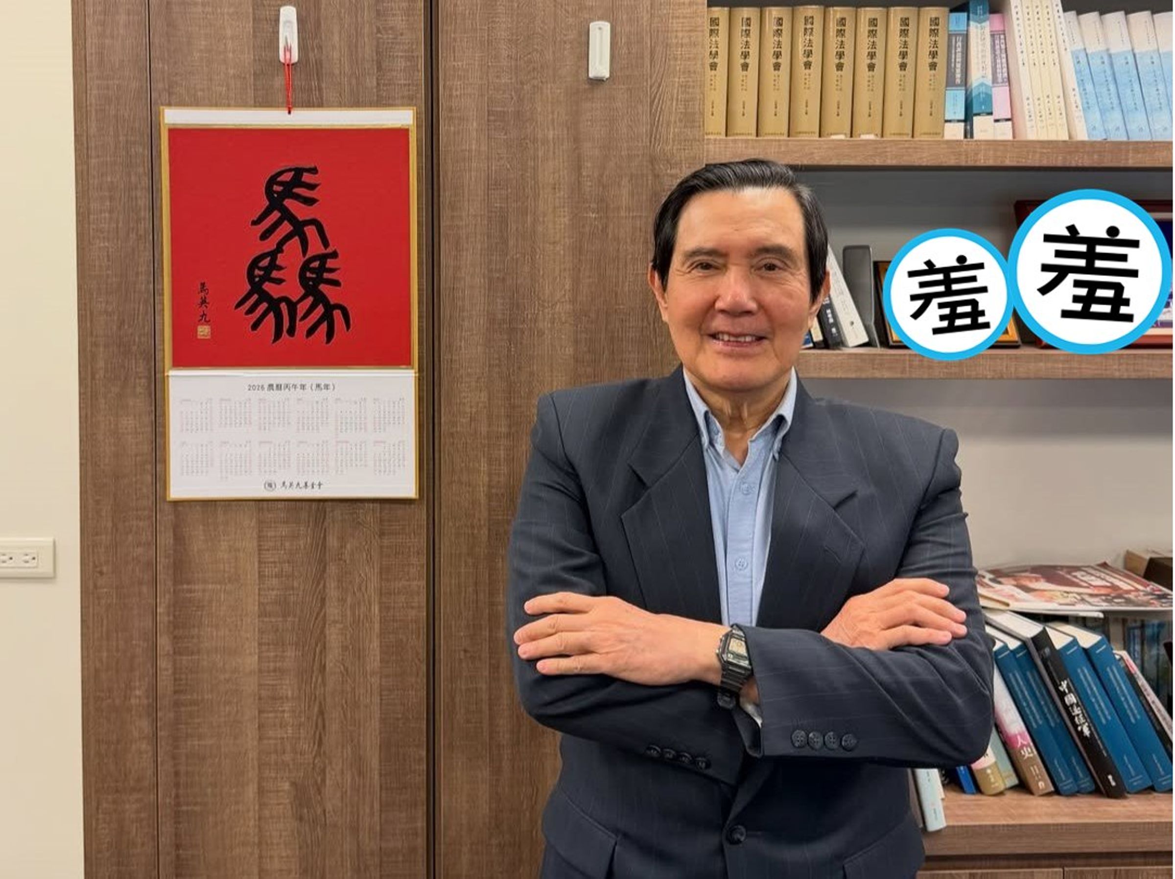 馬英九與自己親筆寫的「驫」字掛曆合照,後方的兩張照片卻意外搶鏡。(翻攝ma_yingjeou
IG)