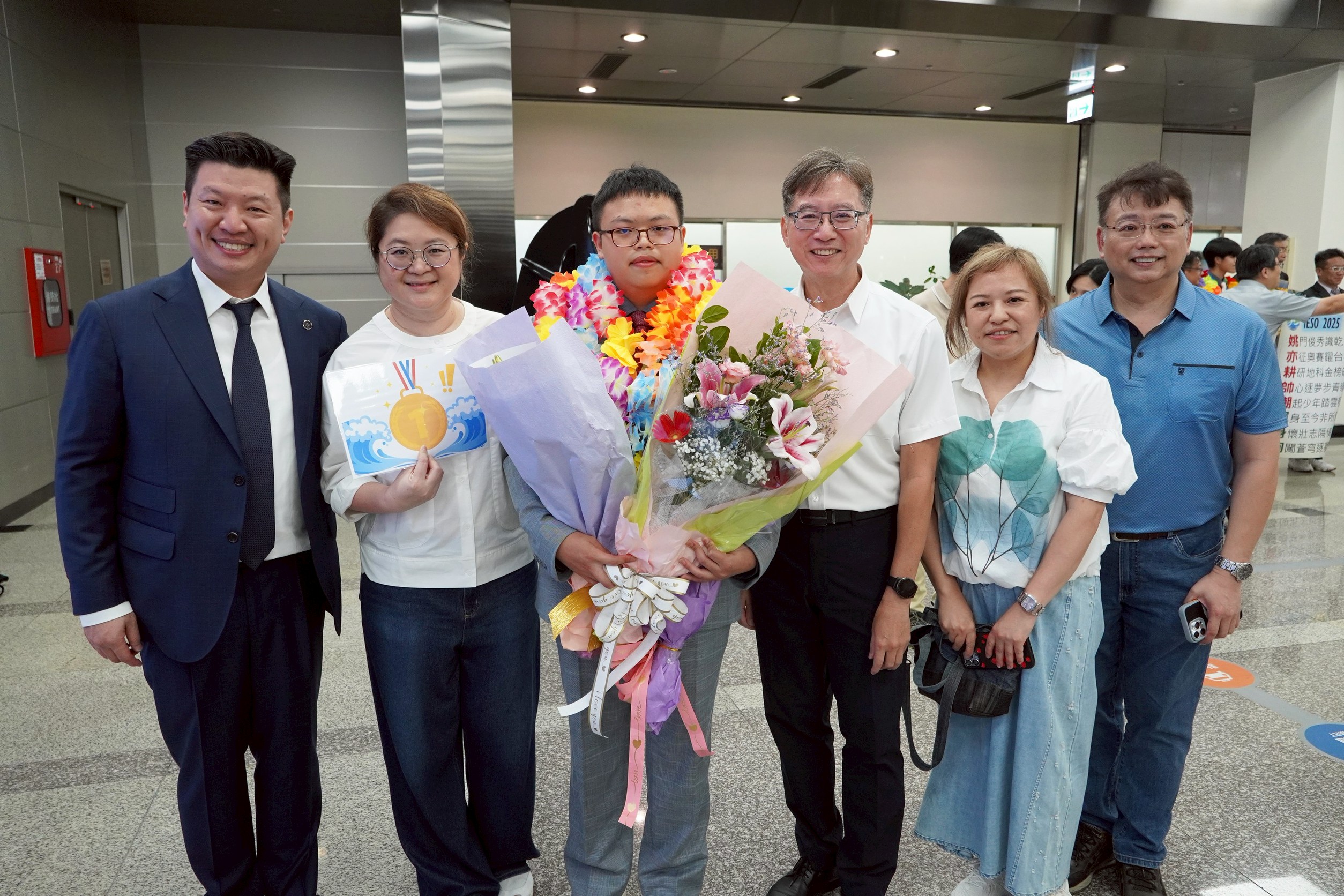 何海銘（中）奪奧林匹亞競賽雙金佳績，財團法人薇閣公益文教基金會董事長李承宗（左一）、薇閣中學校長孫明峯（右三）、薇閣中學導師陳慧芳（左二）、何海銘父母（右一、二）一同合影表揚。（薇閣中學提供）