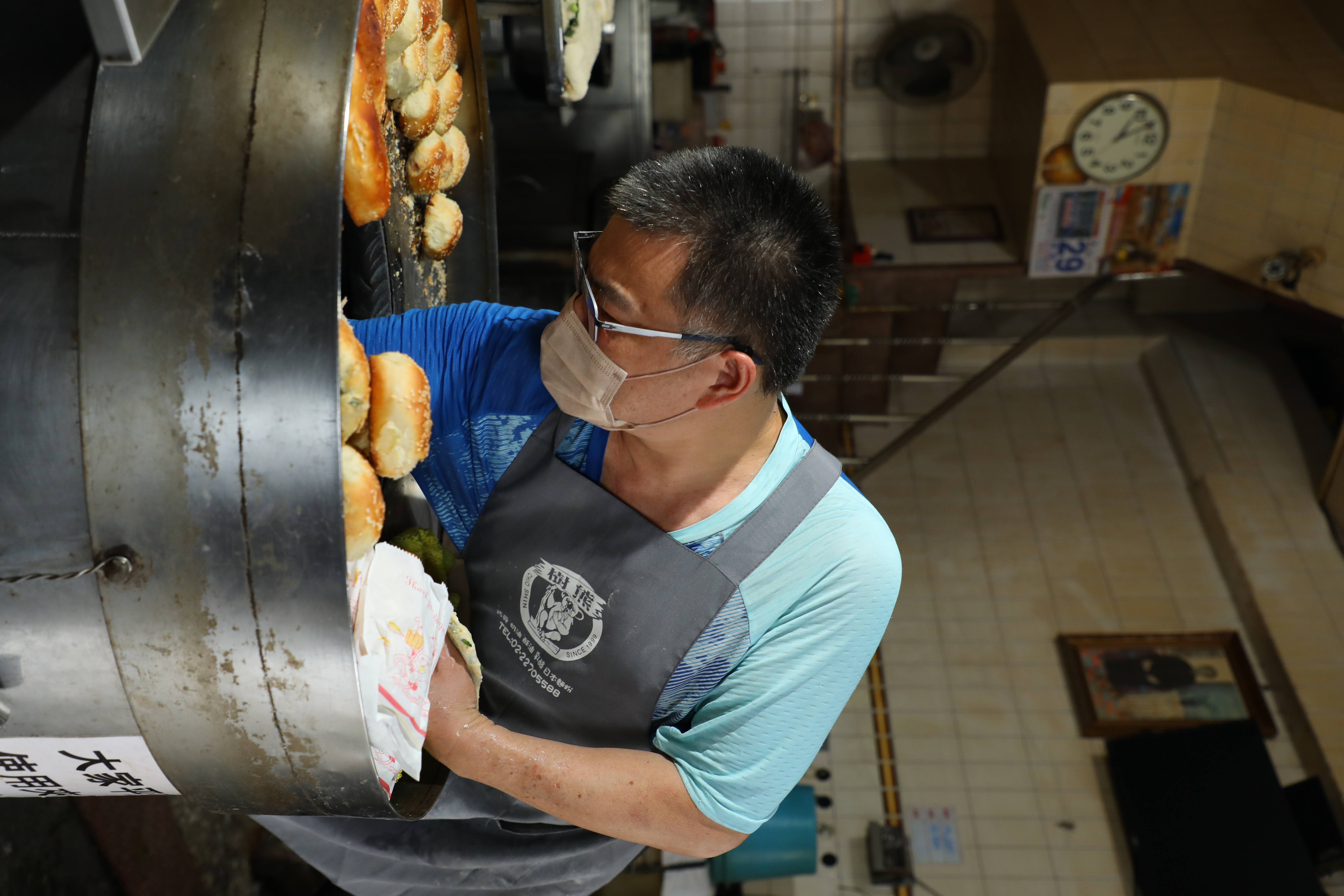 胡椒餅沾水後需由人手伸進炭爐內貼爐,老闆說等滿手都是燙傷疤痕後,就差不多出師了。