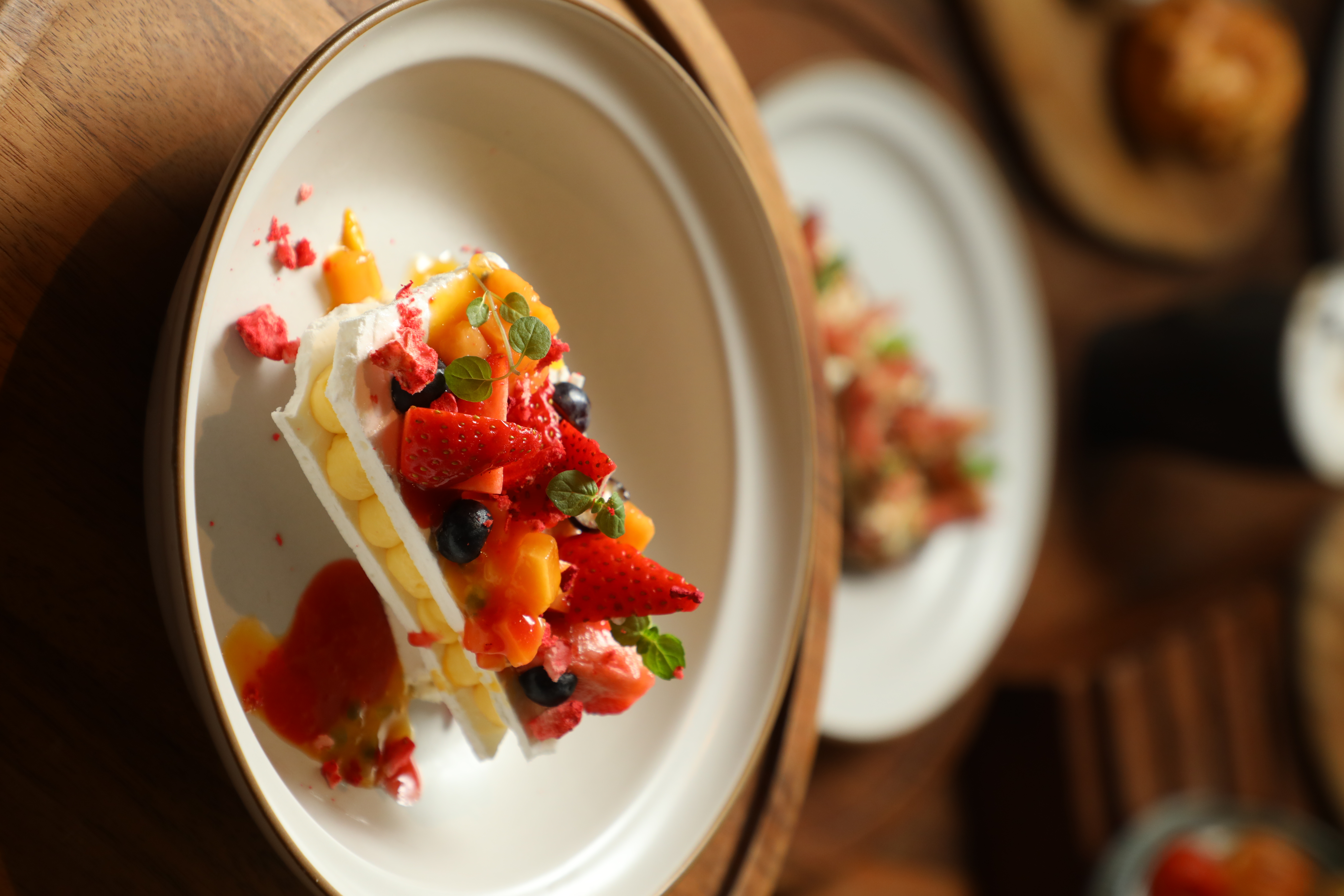 蛋白霜餅包夾百香果甘納許，頂部妝點大量當季鮮果，但「愛漾 Pavlova」的味覺亮點卻是底層的花椒冰糕。