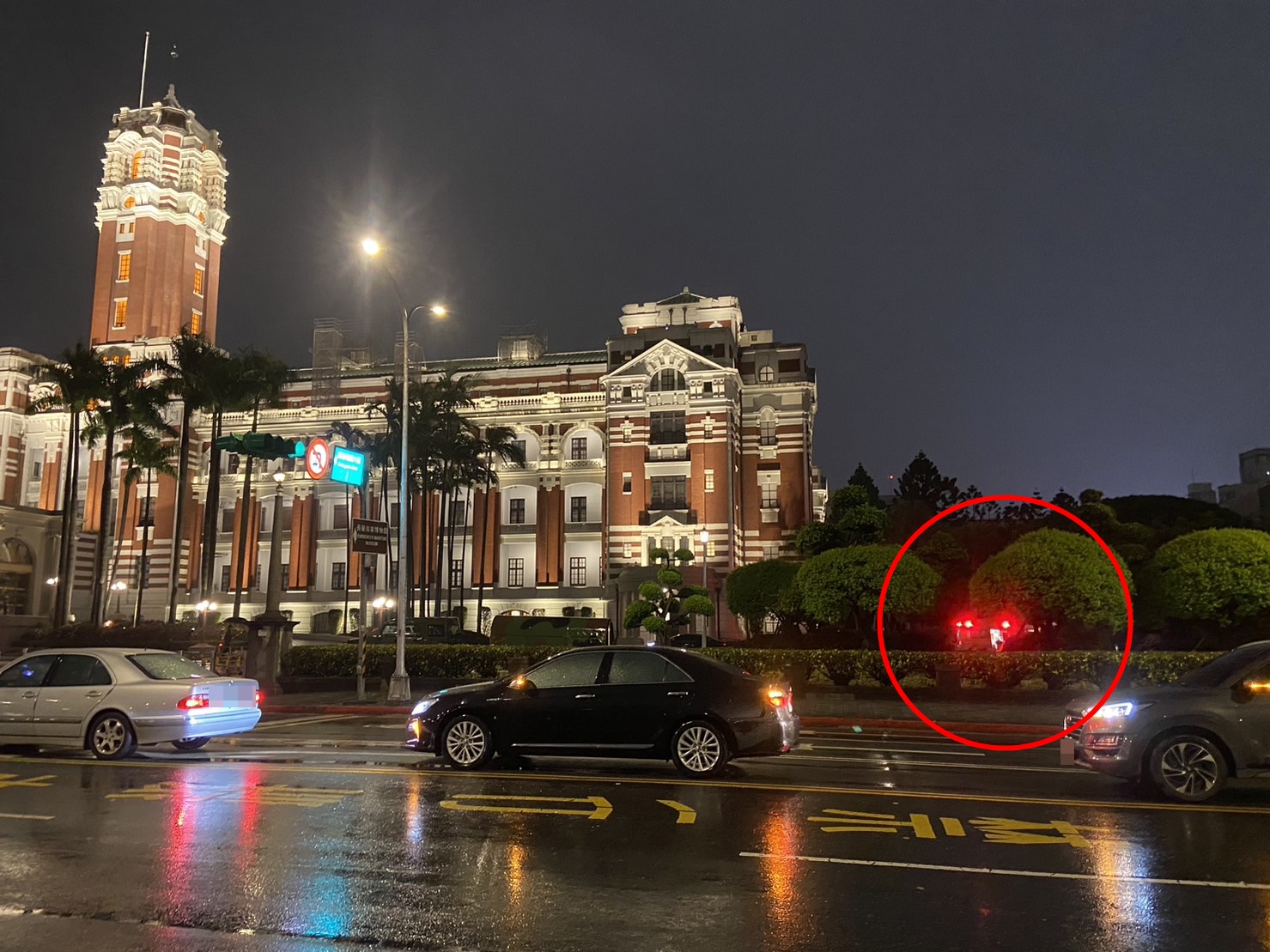 圖中總統府牆內樹叢中的紅光為第一輛進入的救護車。