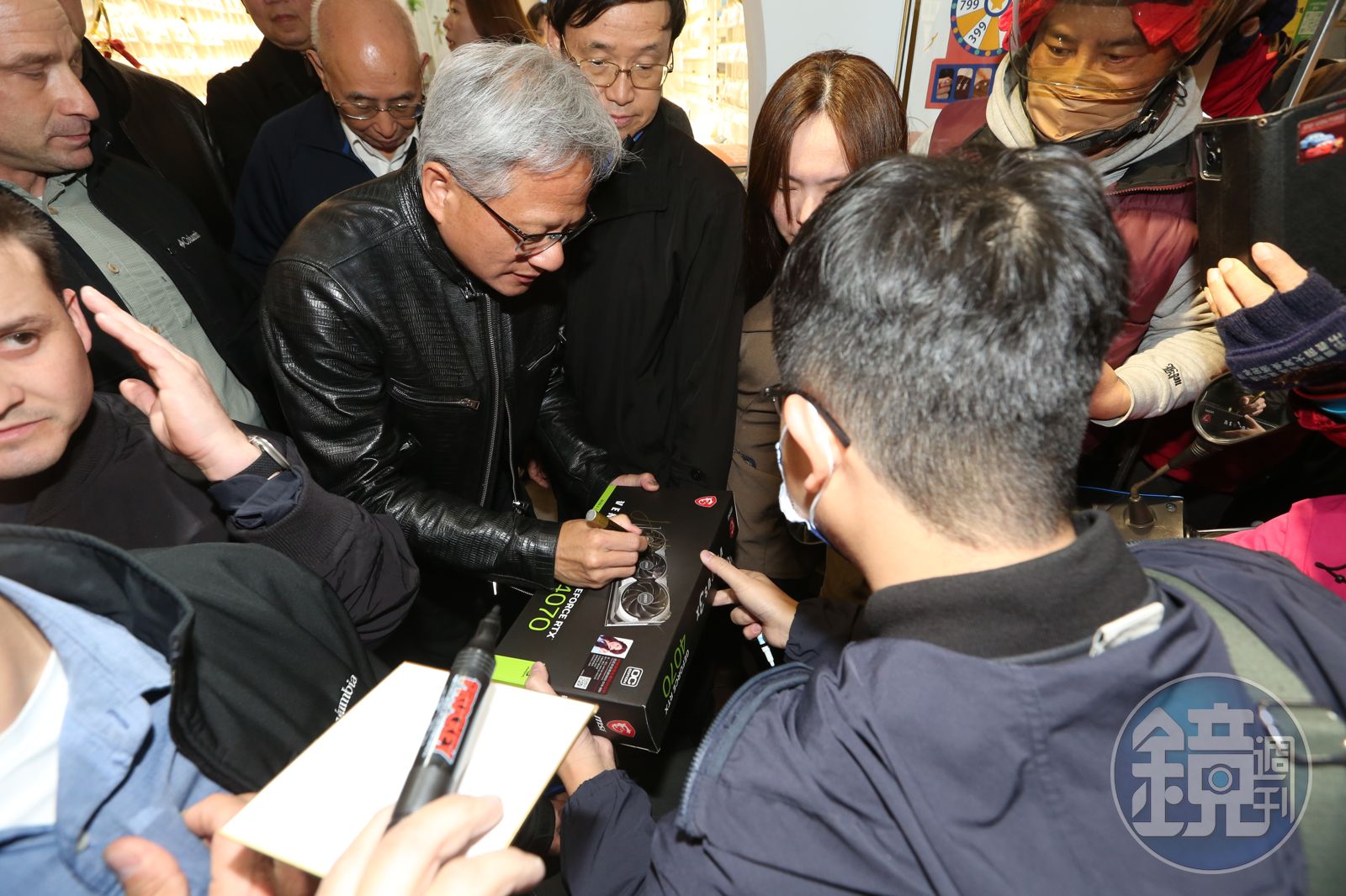 黃仁勳在逢甲夜市為中一中學生簽名。