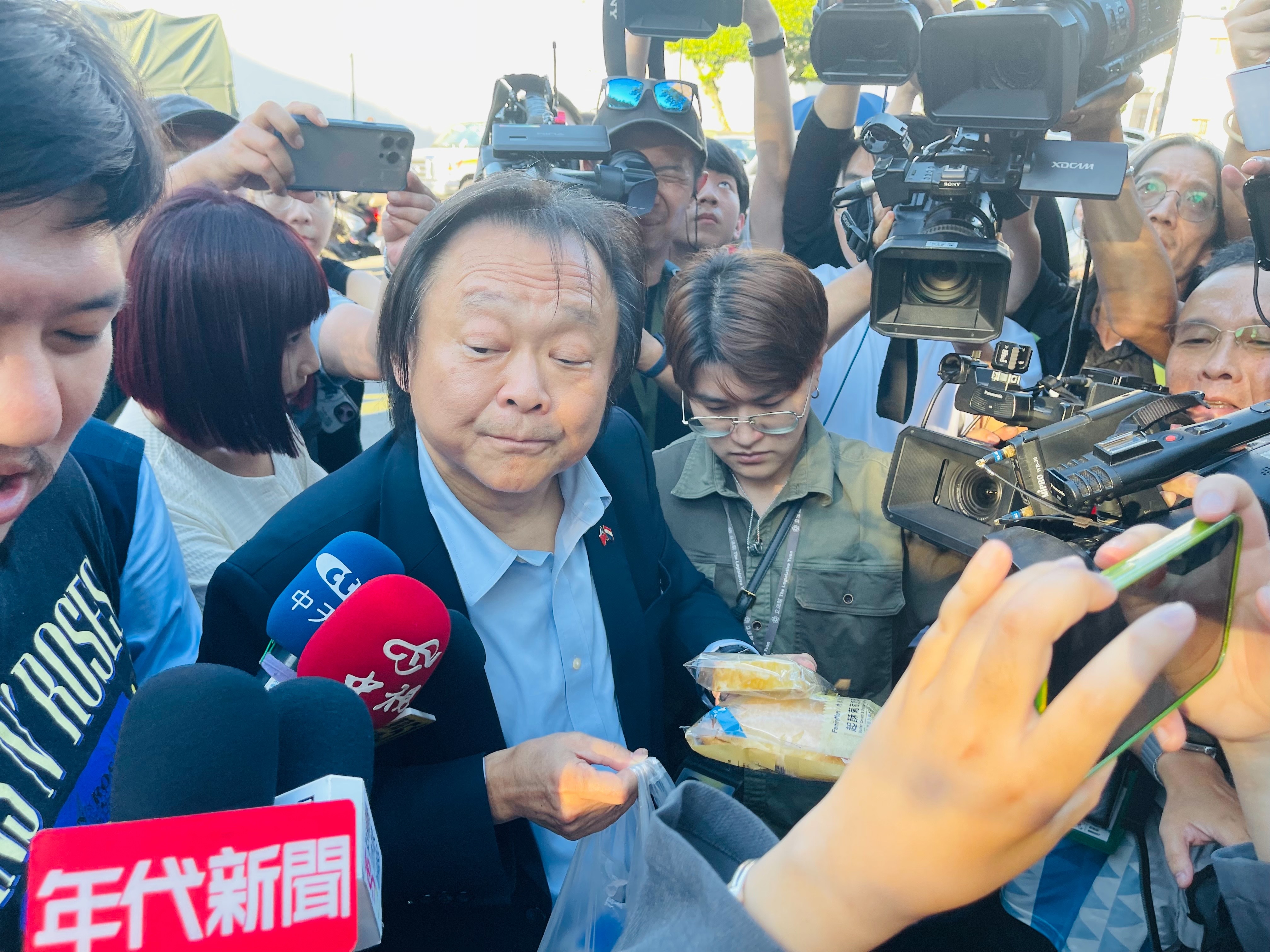 王世堅手持雞鴨便當、起酥蛋糕。