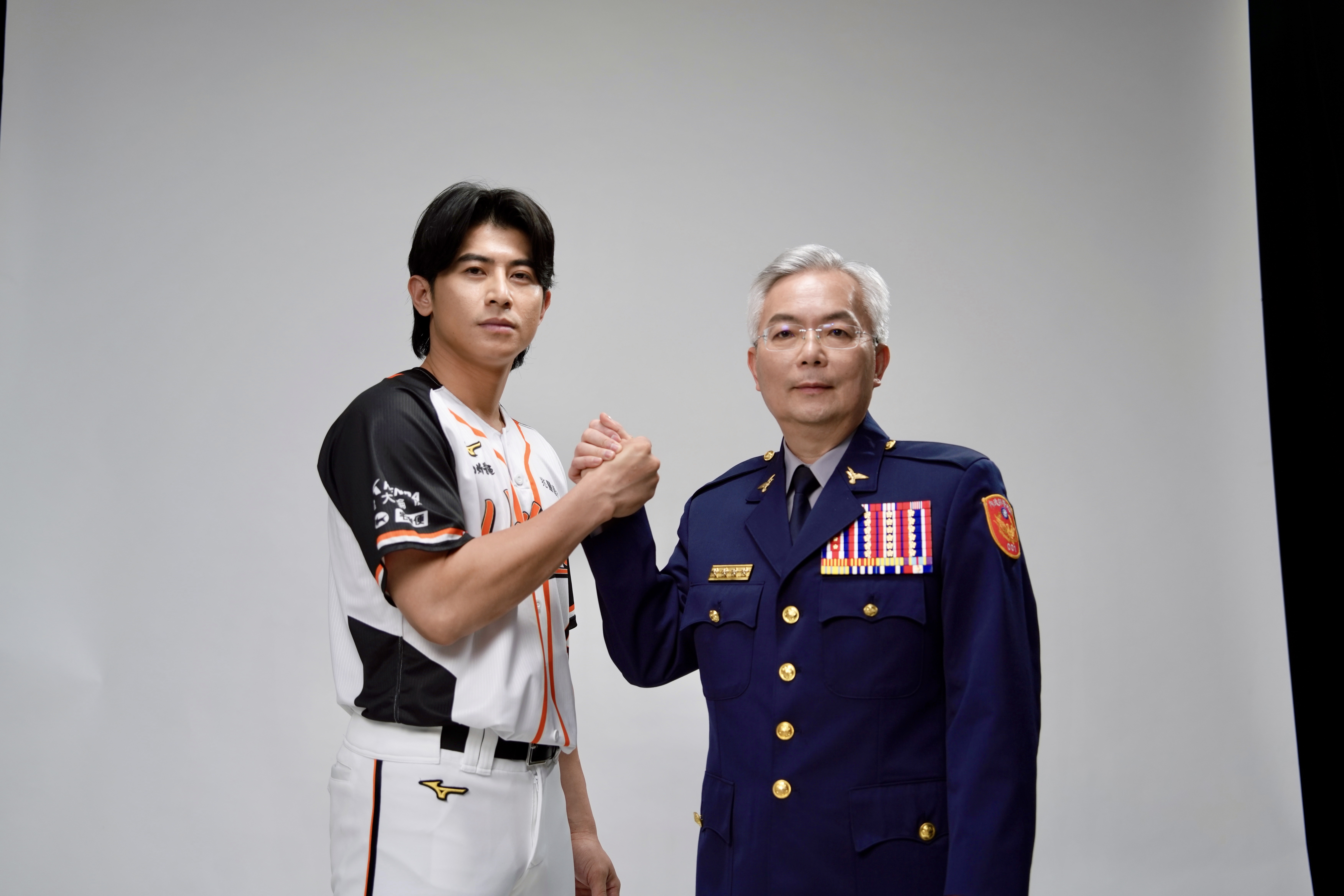 警政署長張榮興（右）與Team Taiwan隊長陳傑憲合拍防詐公益廣告。（刑事局提供）