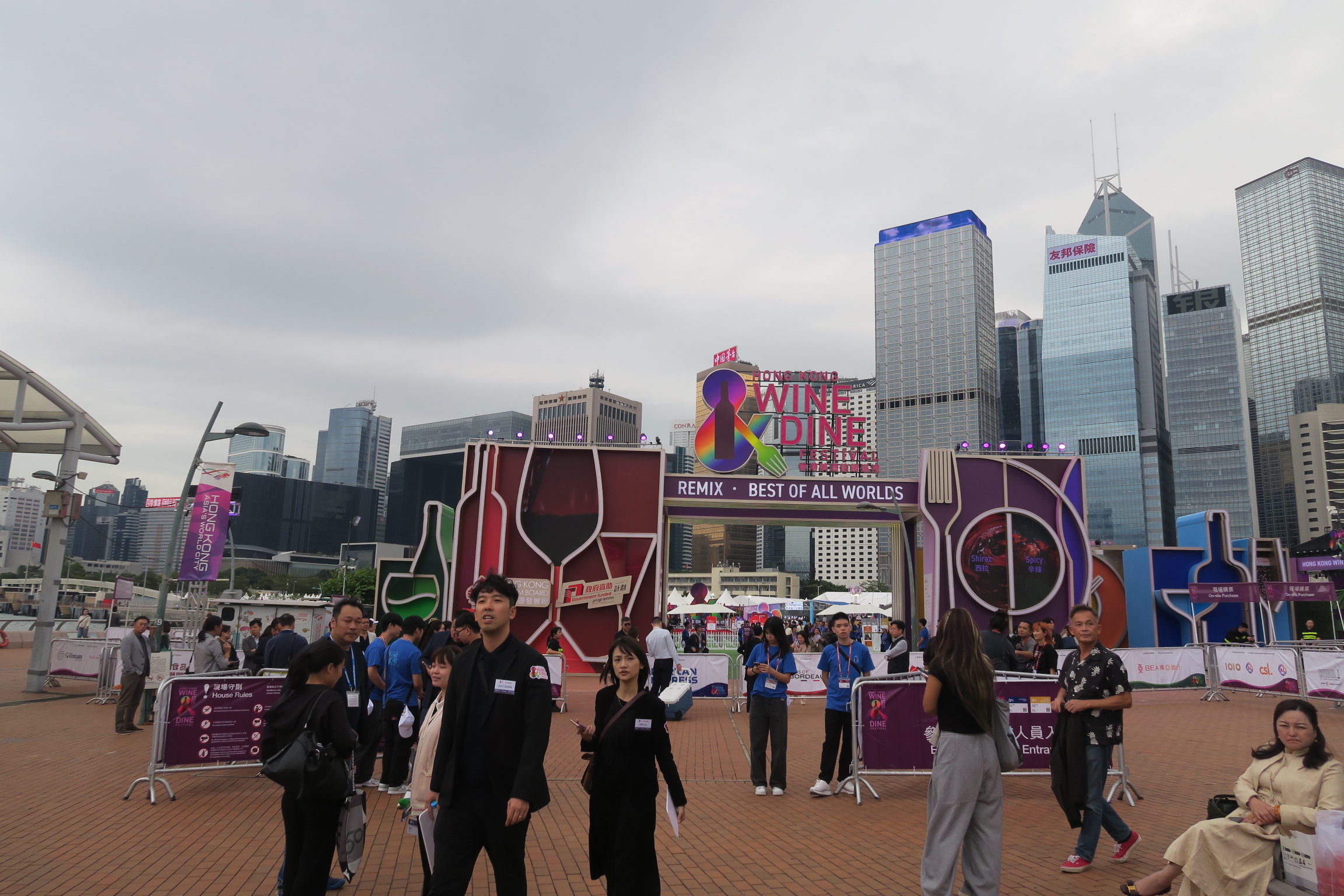 香港美酒佳餚巡禮現在固定在中環海邊摩天輪旁空地舉辦，門口裝飾著酒瓶酒杯與刀叉，場內也匯聚世界美酒與美食。