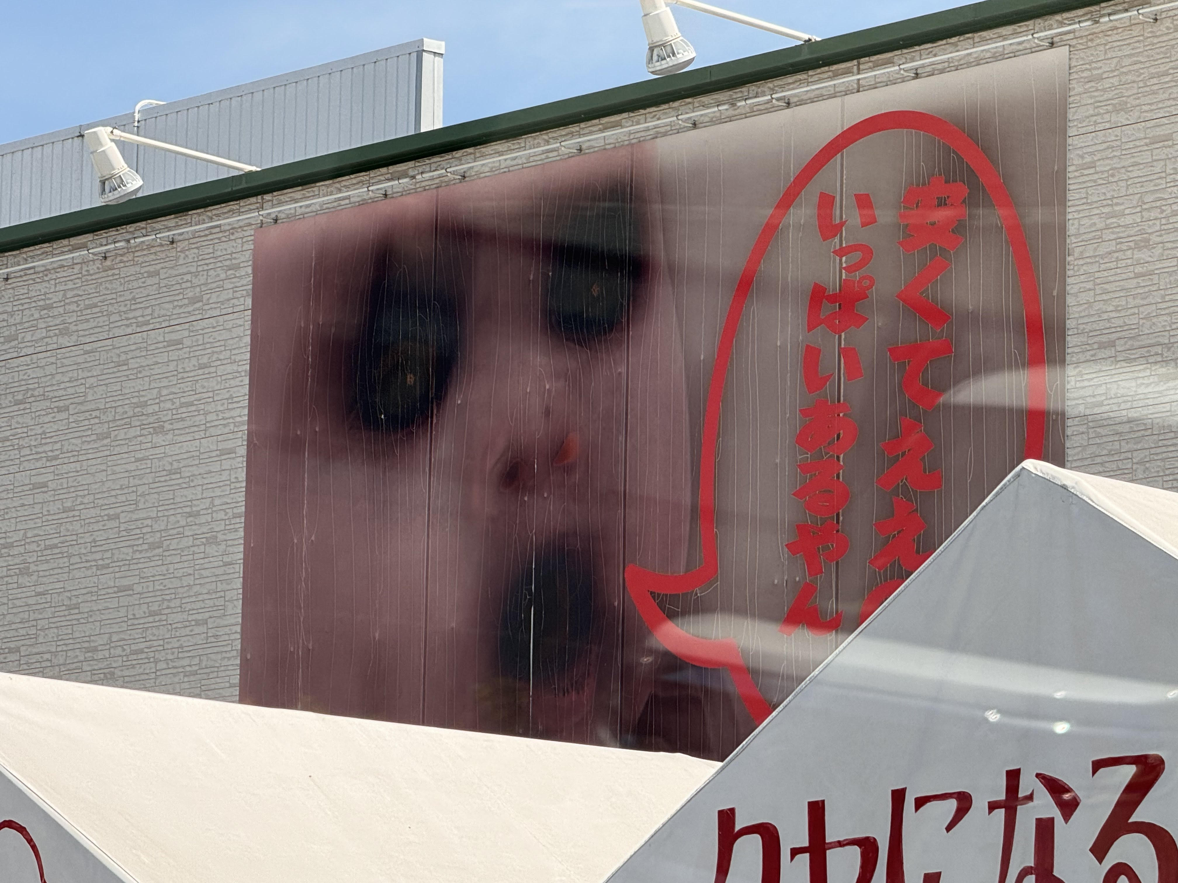 「はんがい」商店寶寶招牌因熱浪融化墨水，轉變成鬼娃風格。（翻攝X@lcqpi）