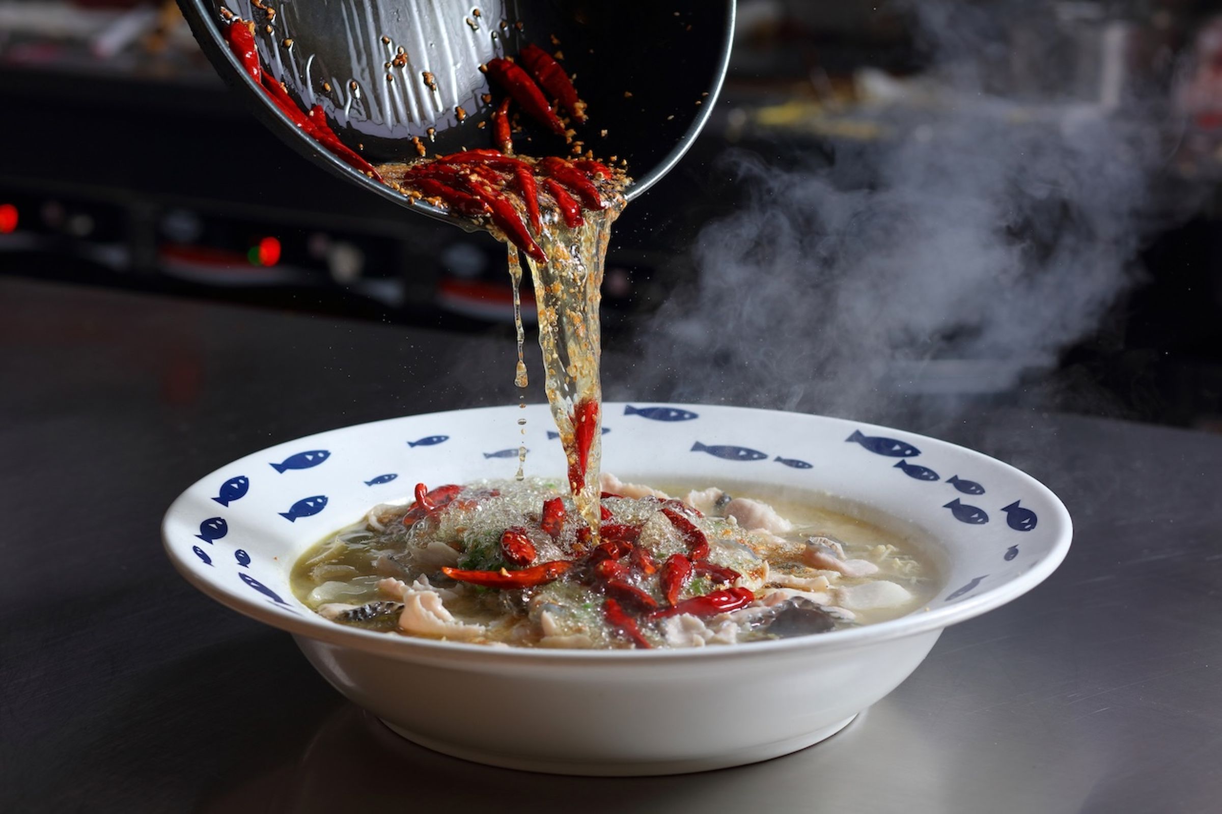每份酸菜魚，會分別再沖入辣椒、白芝麻、蒜末特製的熱油爆出香氣。