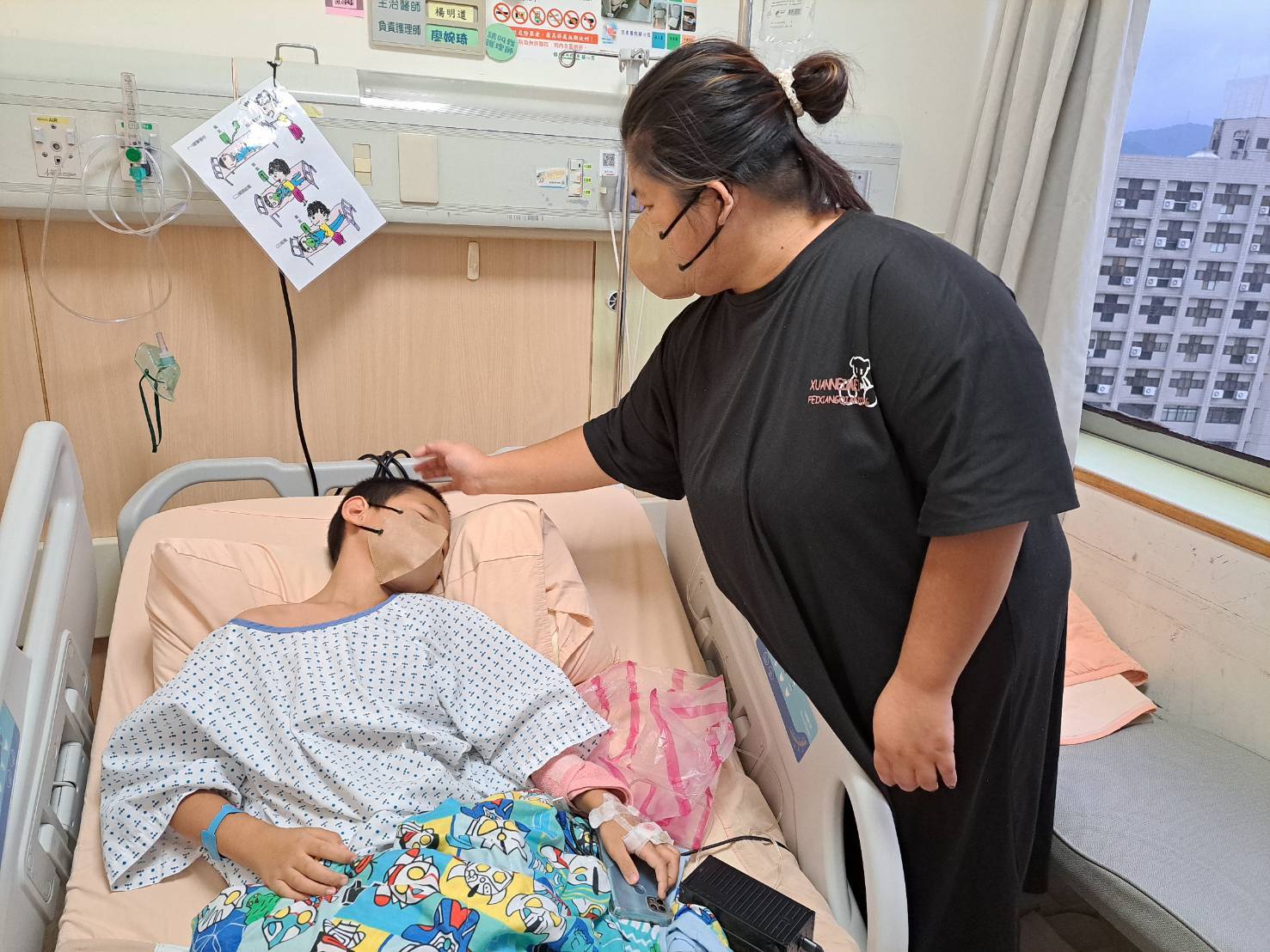 吳媽媽在亞東醫院照顧次子。(新北市社會局提供)
