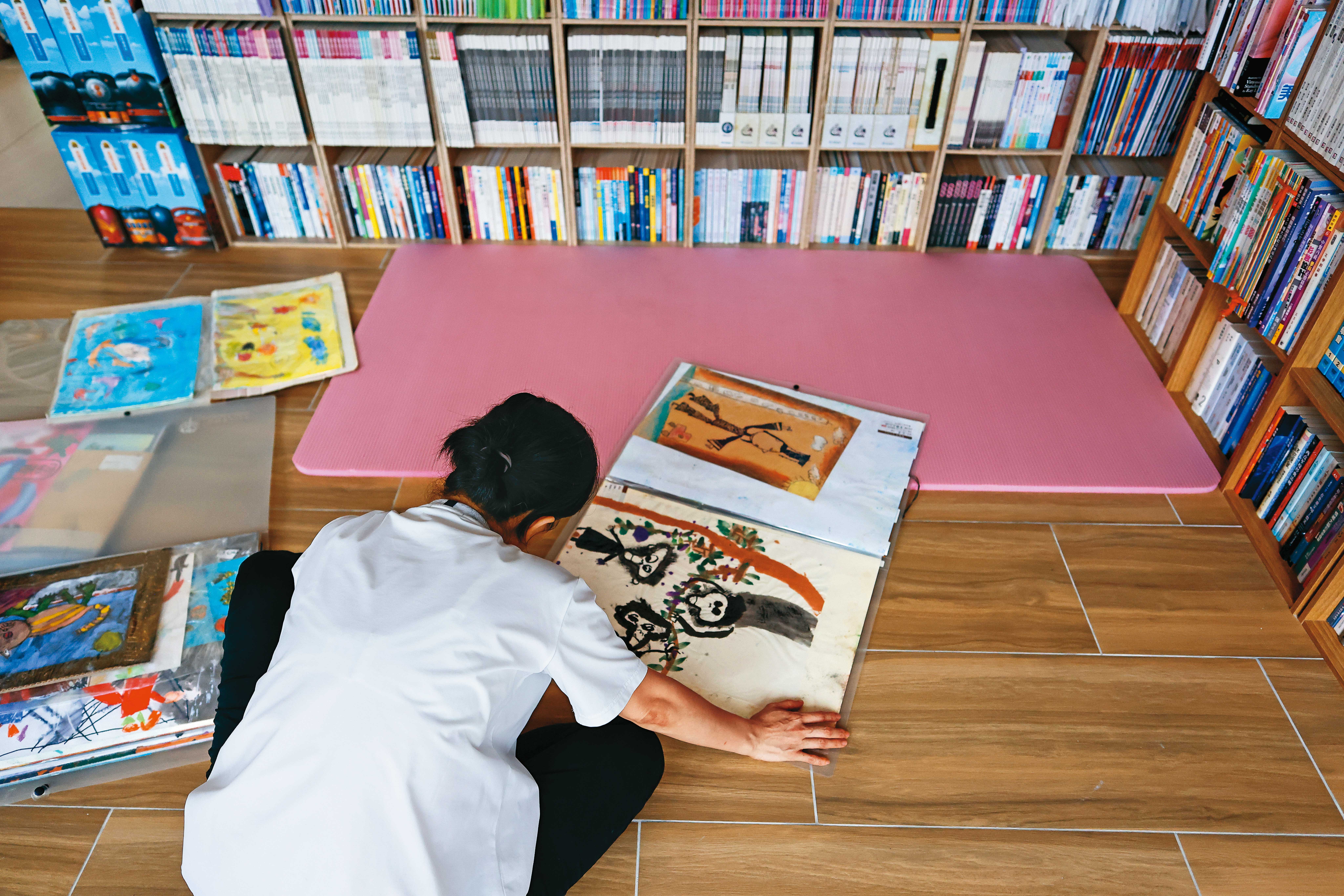 小宇的母親翻著小宇幼時畫作，可看出他極具天賦。