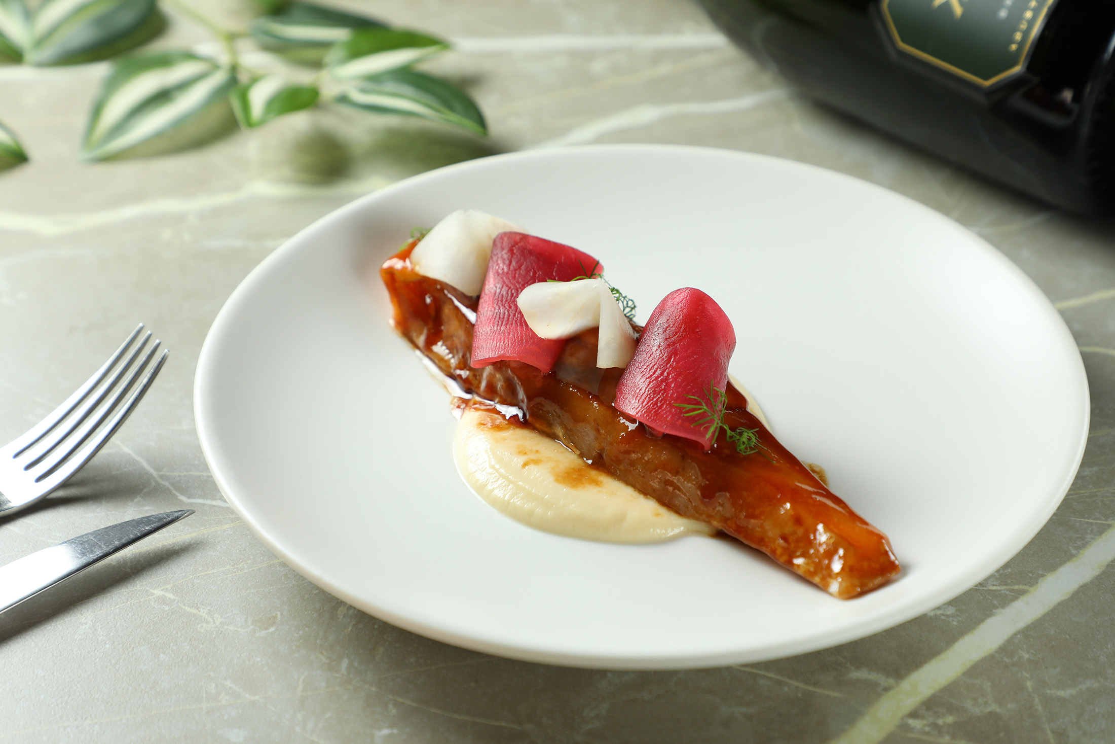 「慢烤季節鮮魚」淋上以雞骨、胡椒、乾蔥等香料熬製的半釉汁，為魚肉帶來深邃風味。（660元／份）