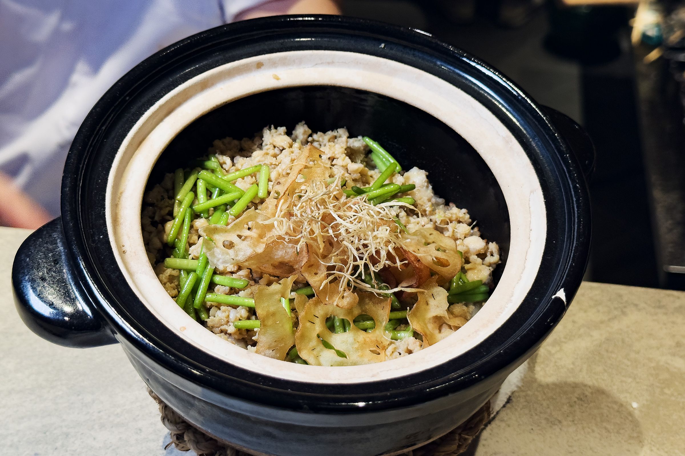 「雞肉末土鍋飯」以雞湯炊煮,揭蓋瞬間熱氣與米香升騰,拌入水蓮與牛蒡絲,層層堆疊出溫潤收尾。